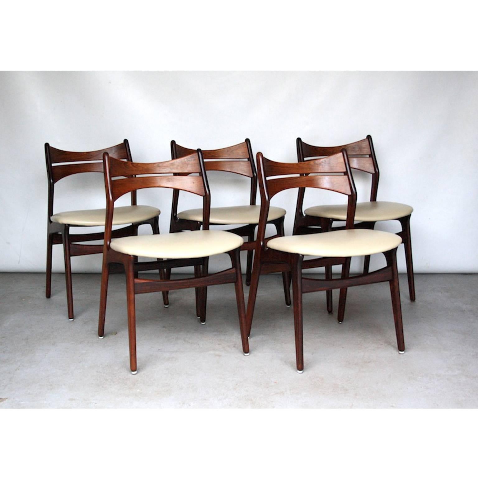 Danish dining chairs in rosewood by Erik Buck. Erik Buck is the creator of many famous bar stools, but also designed dining chairs. These chairs are made of solid rosewood and upholstered in stylish cream colored vinyl.
The chairs are marked with