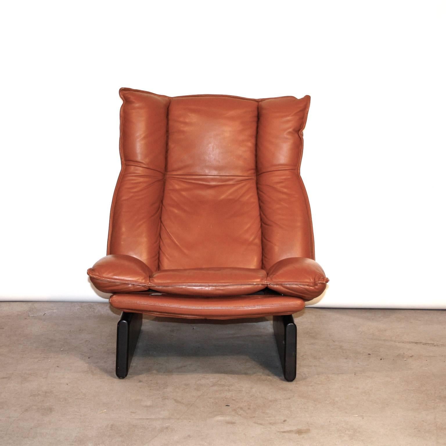 Lounge chair in leather from the 1970s by the Dutch manufacturer Leolux. With a solid wooden base. Good condition with a tiny barely visible repair to the lower side.