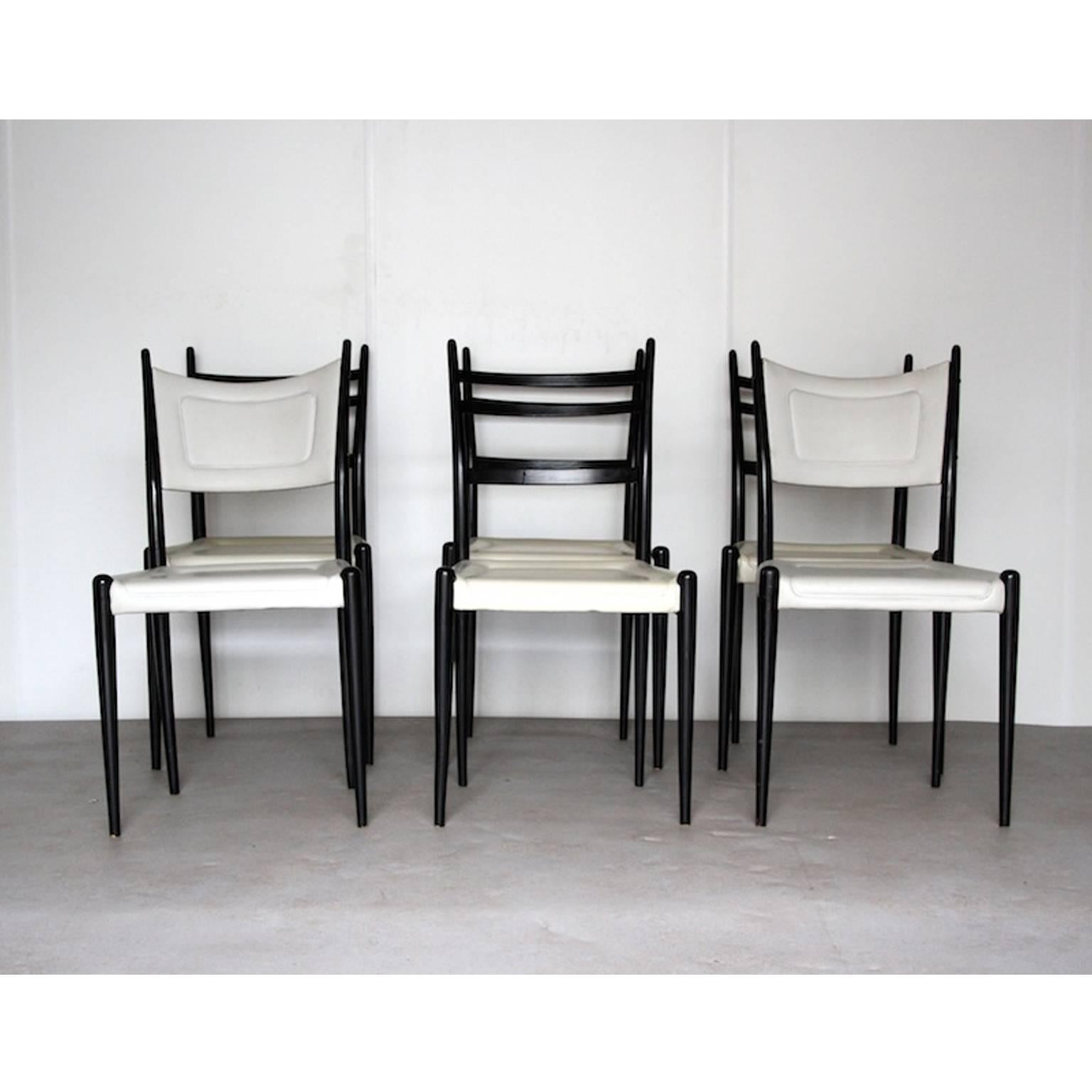 Fantastic elegant dining chairs that look Italian made, but are actually British! These chairs are made of black painted wood with a white faux leather seating. Two of the chairs have their back upholstered in the same faux leather. They were made