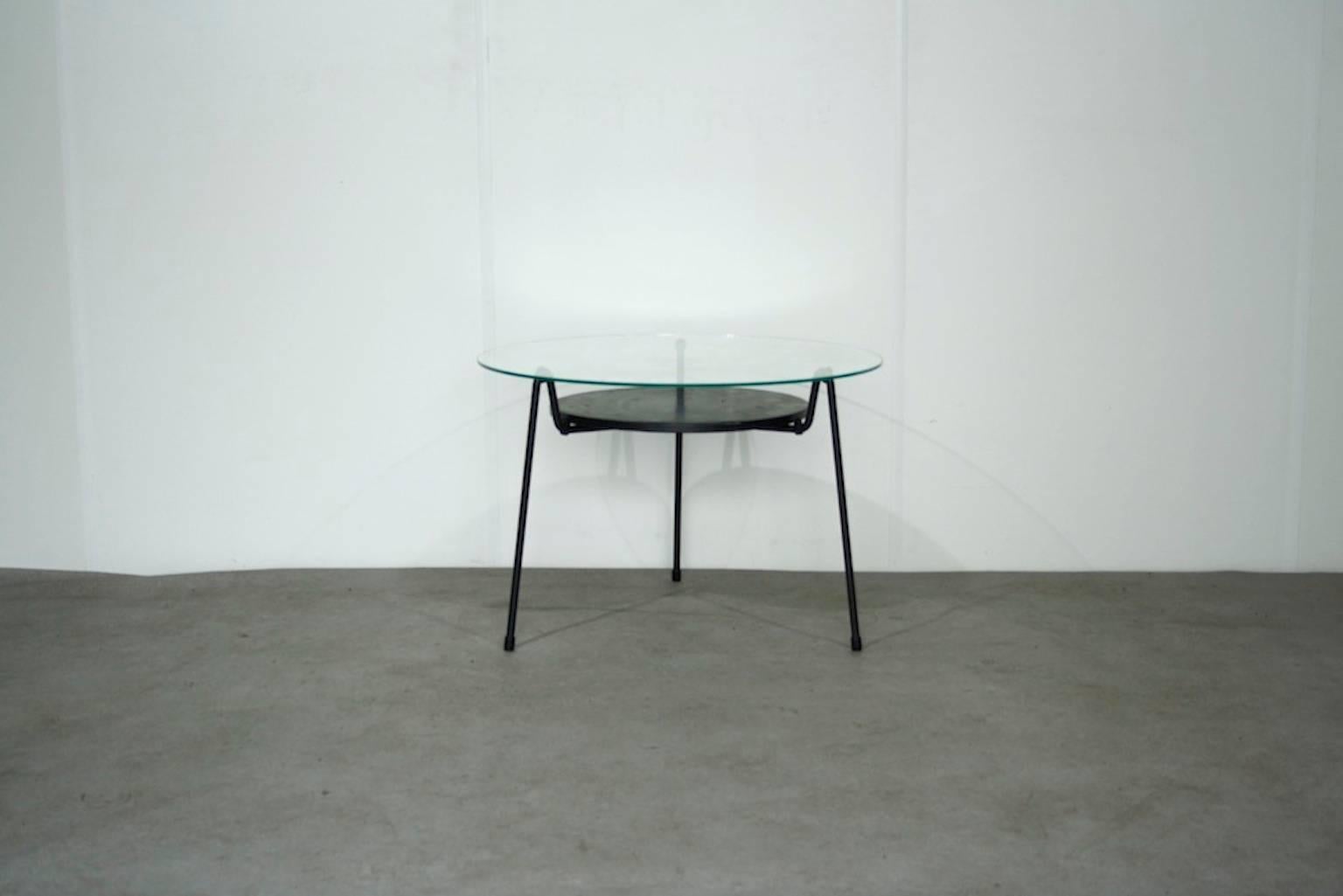 Round black metal coffee table with glass top.