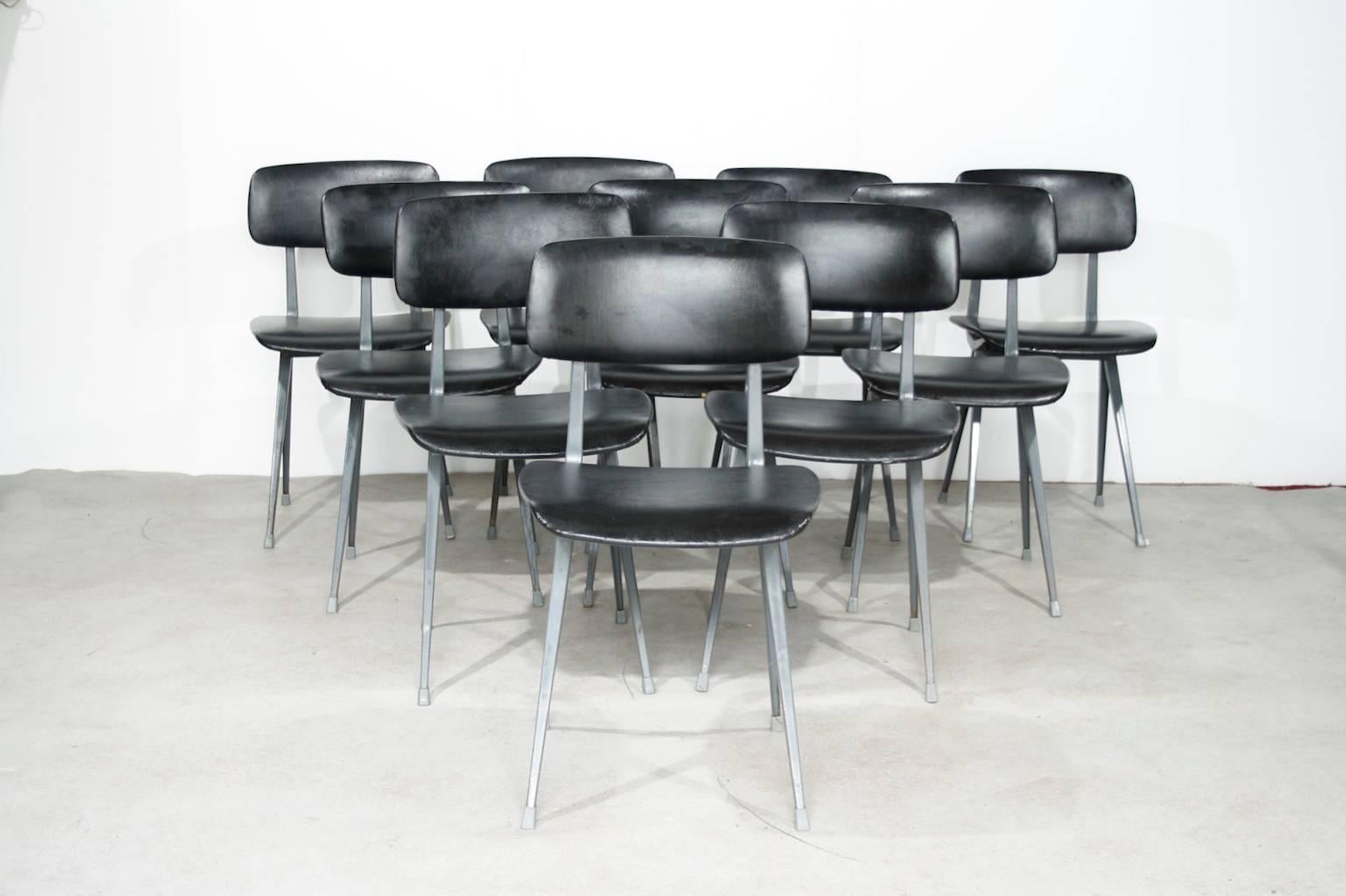 Set of ten Result chairs with a light-grey metal frame and the original black faux-leather upholstery.
They all have signs of use, like rust to the frame, and around three chairs have some small holes in the fabric.
Most of them are still marked