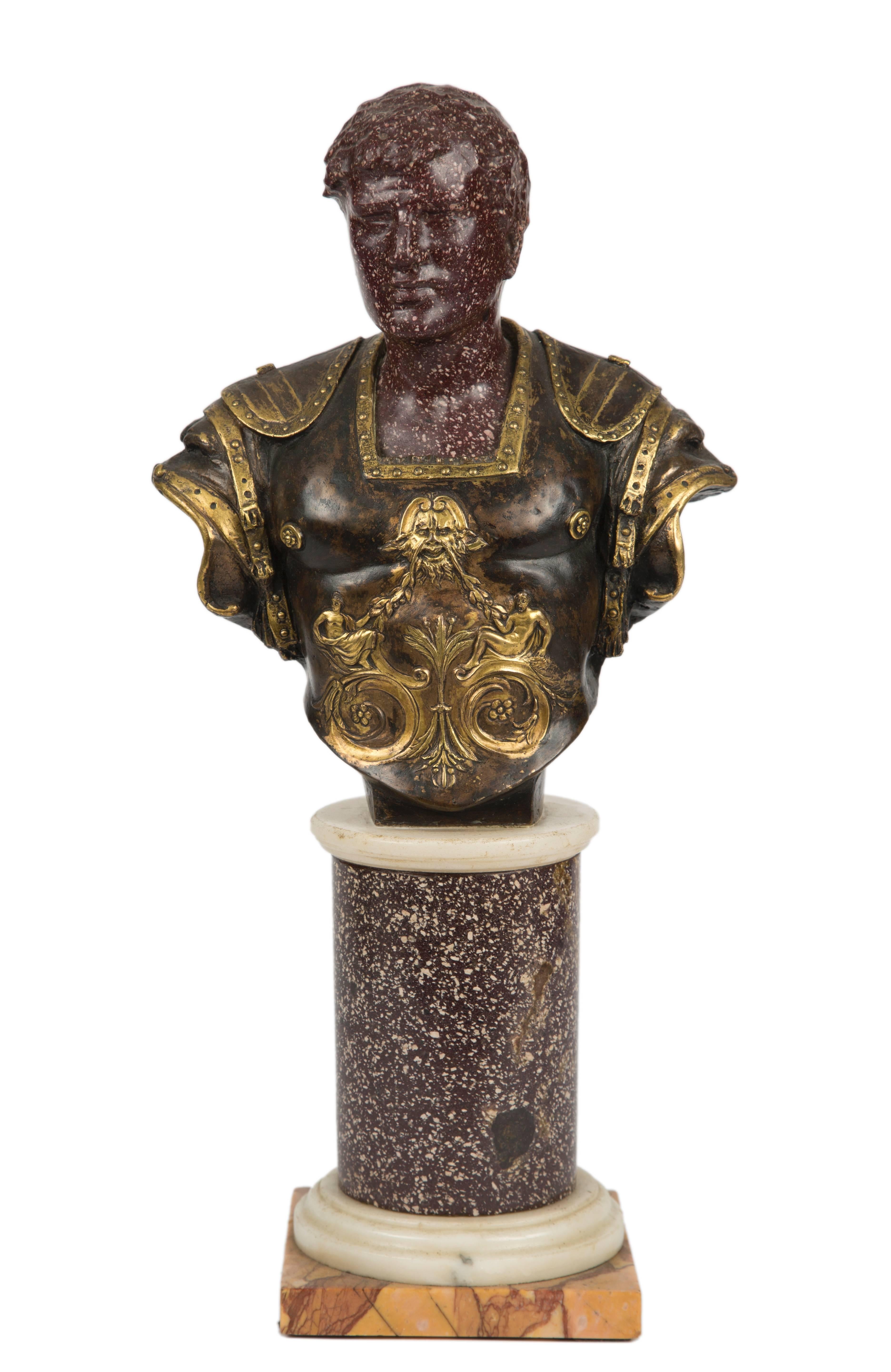 Italian carved porphyry bust of Roman emperor, most likely Caracalla with gilt bronze and patinated mounted armor. Bust is raised on porphyry, white marble, Giallo di Siena pedestal.
