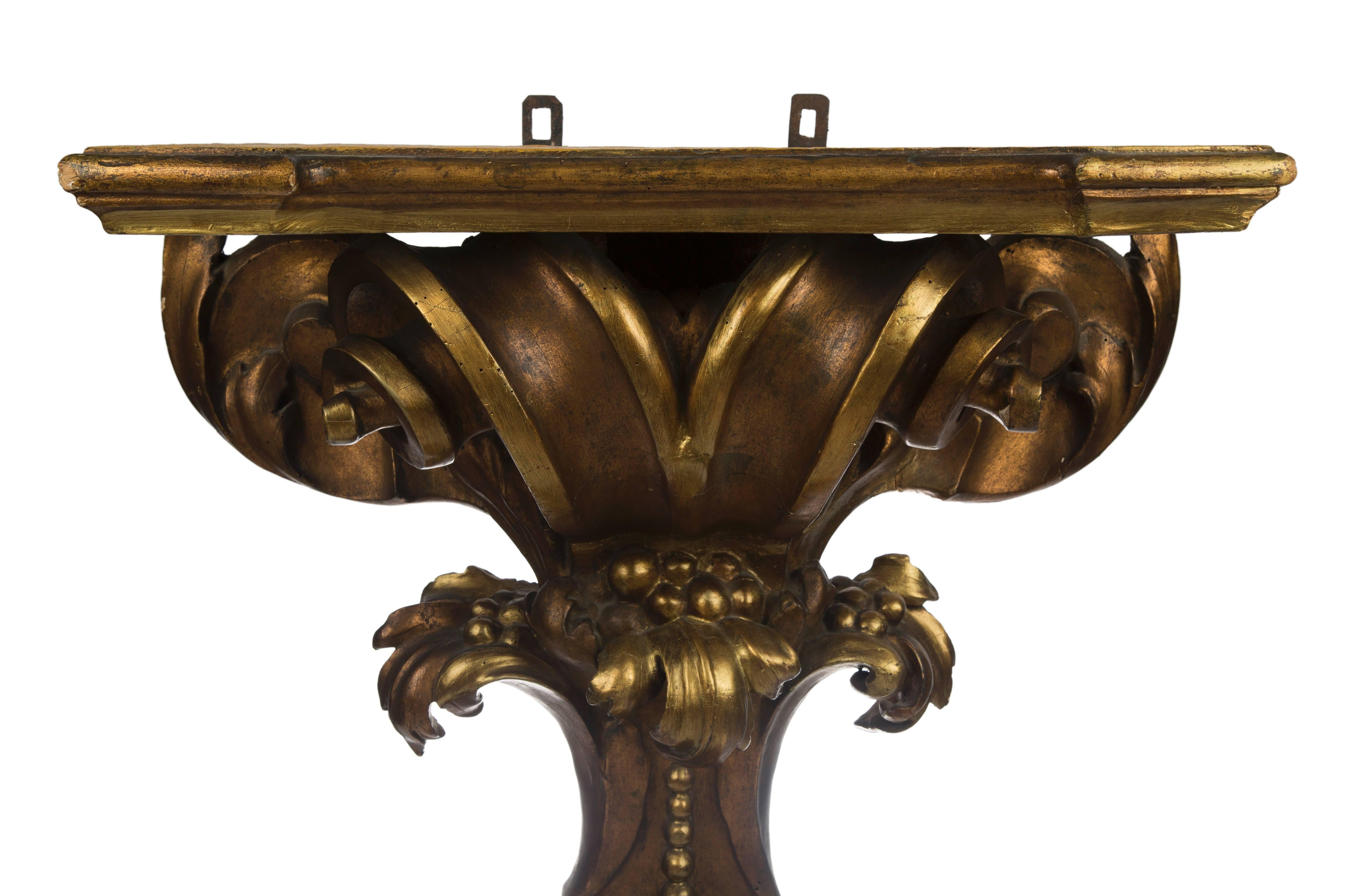 Ornate baroque carved giltwood console with foliage and scroll ornaments raised on shaped out-stepped plinth,
Italian, 18th century.