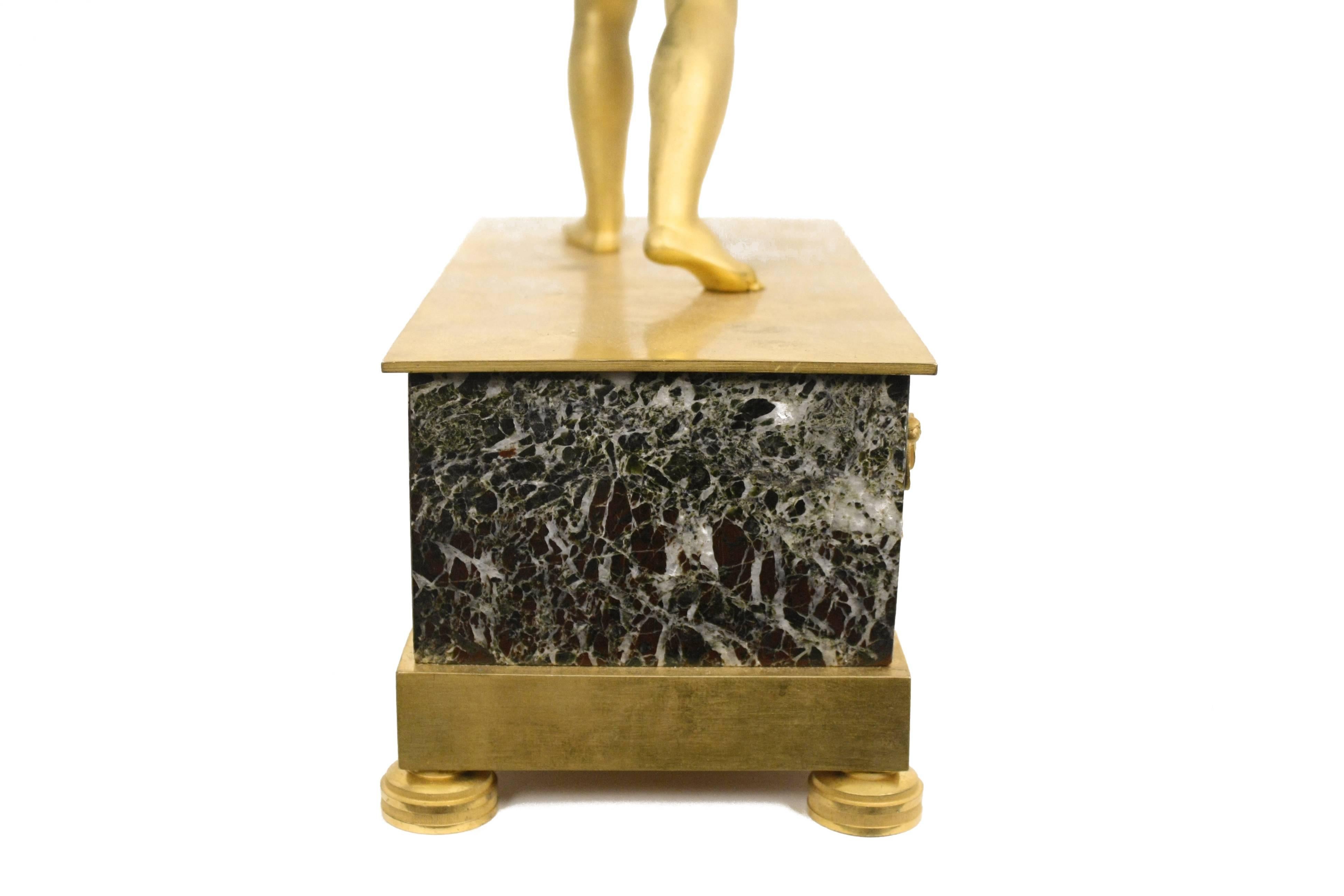 Doré Pendule de cheminée Empire français en bronze doré à motifs figuratifs en vente