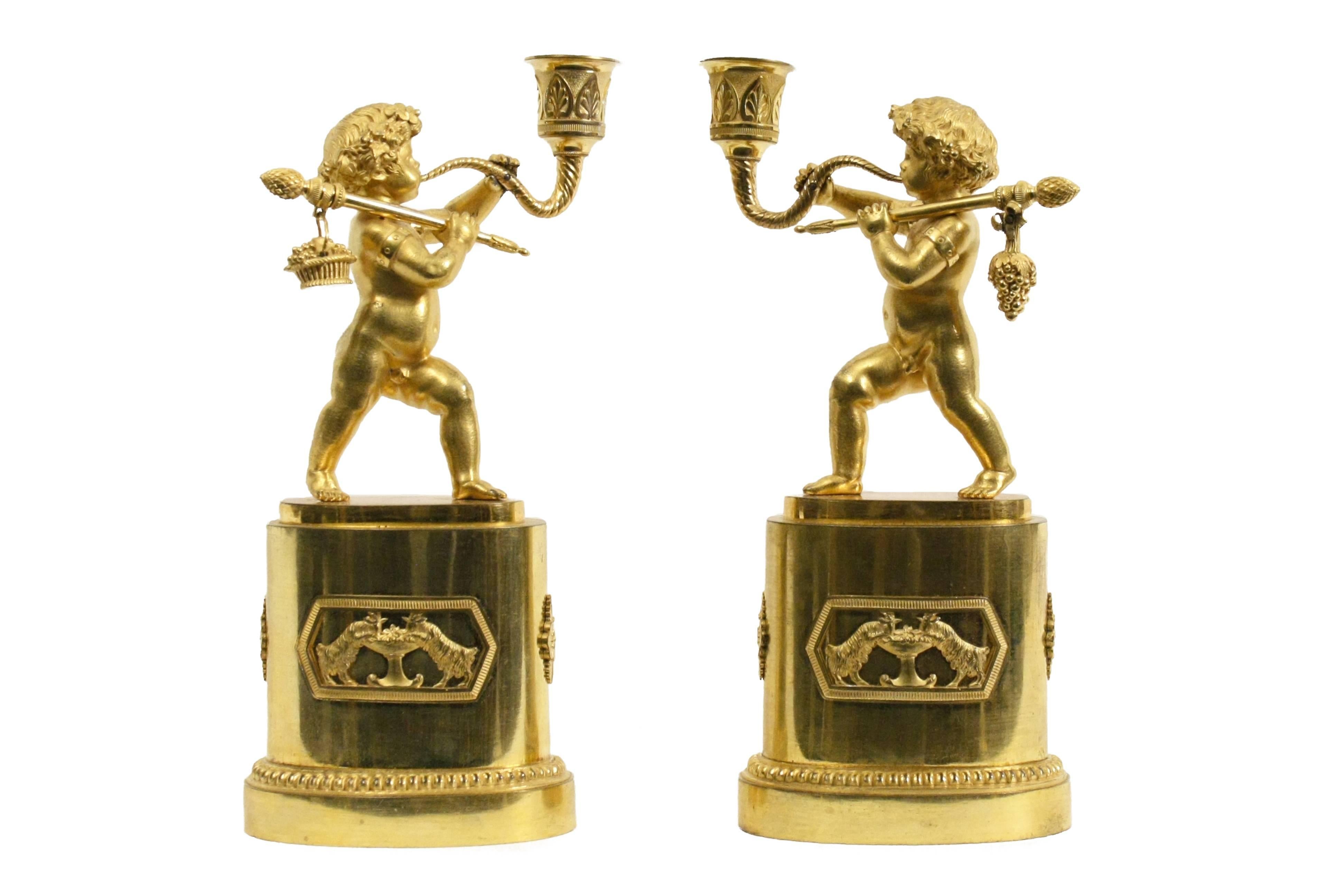 Pair of candlesticks modeled as standing putti blowing a horn with grapes and fruit base hanging over their shoulders, after Claude Galle.

Measures: H 11-1/4 in, W 6-1/2 in.