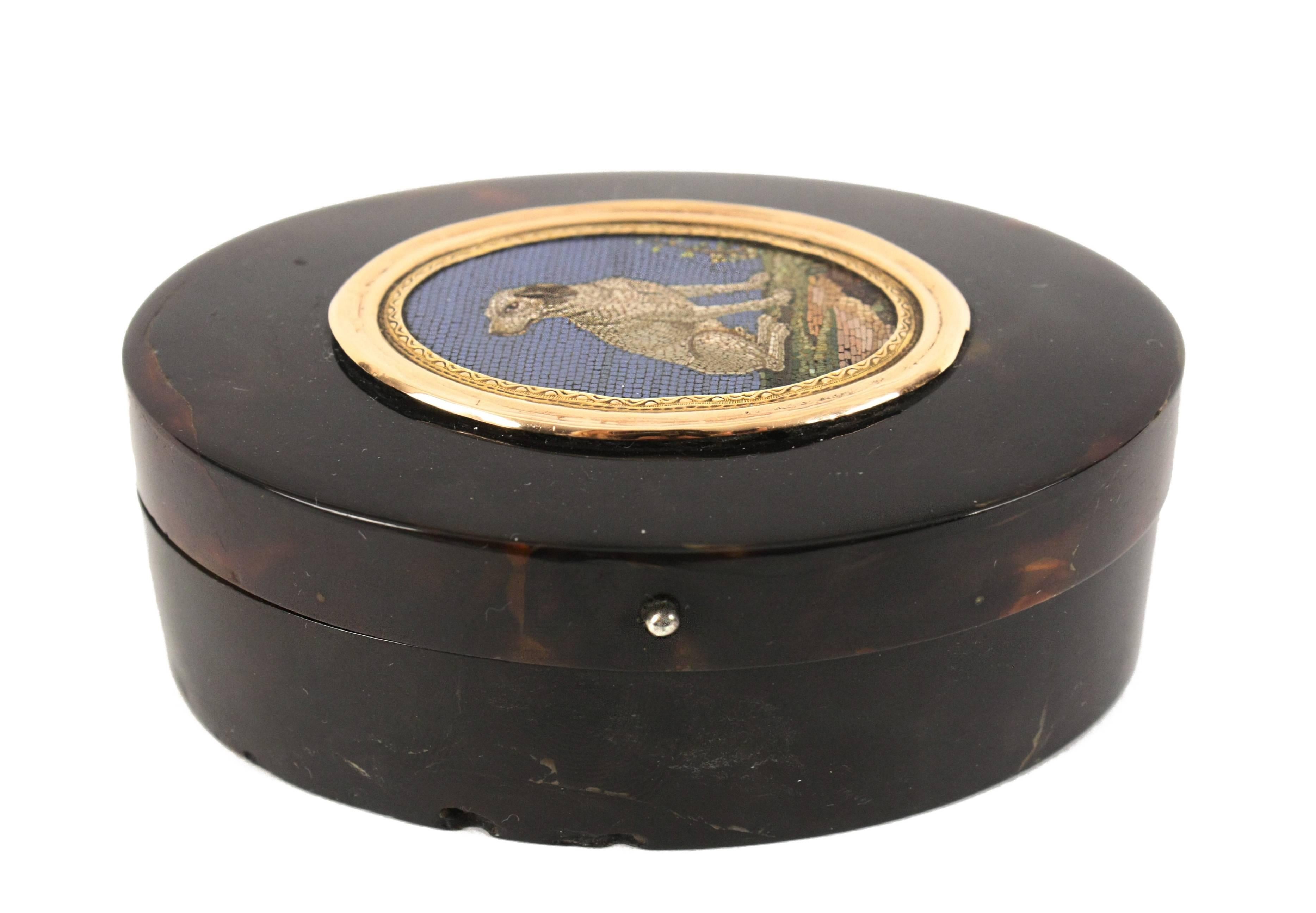 Italian micro mosaic plaque mounted within snuff box, depicting white and brown hound seated on grass.
Circle of Giacomo Raffaelli (1753-1836).

Rome, Italy, circa 1800s.
Mosaic measures 2 in.
 