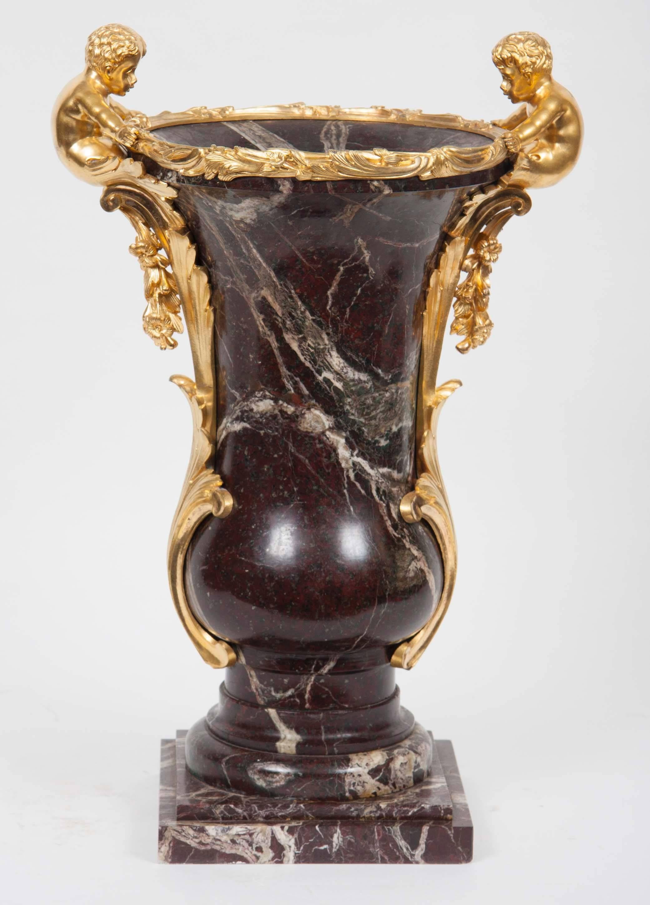 Zwei in Ormolu gefasste Marmorvasen mit kunstvollen vergoldeten Bronzeblättern und figuralen Fassungen, die die Urnen einrahmen.
Frankreich, 19. Jahrhundert.
Maße: 20-1/2 Zoll (52cm) Höhe.

NMA Inv. 454