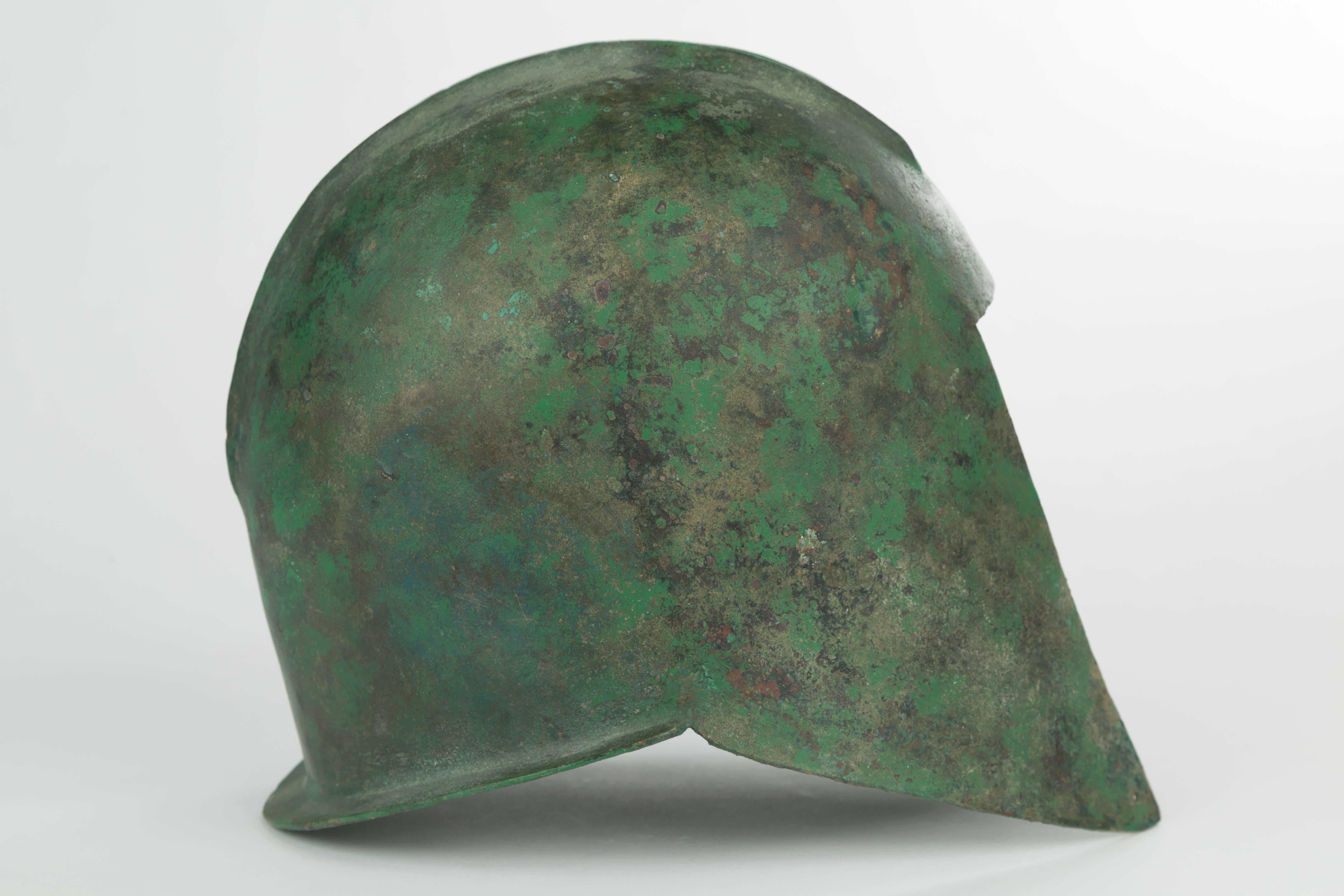 Illyrischer Helm aus griechischer Bronze
Archaische Periode, ca. 500-500 v. Chr.
Aus Bronzeblech gehämmert, gewölbte Form mit zwei parallelen Rippen an der Schale, einem geraden Visier, zwei erhabenen parallelen Rippen, die von vorne nach hinten