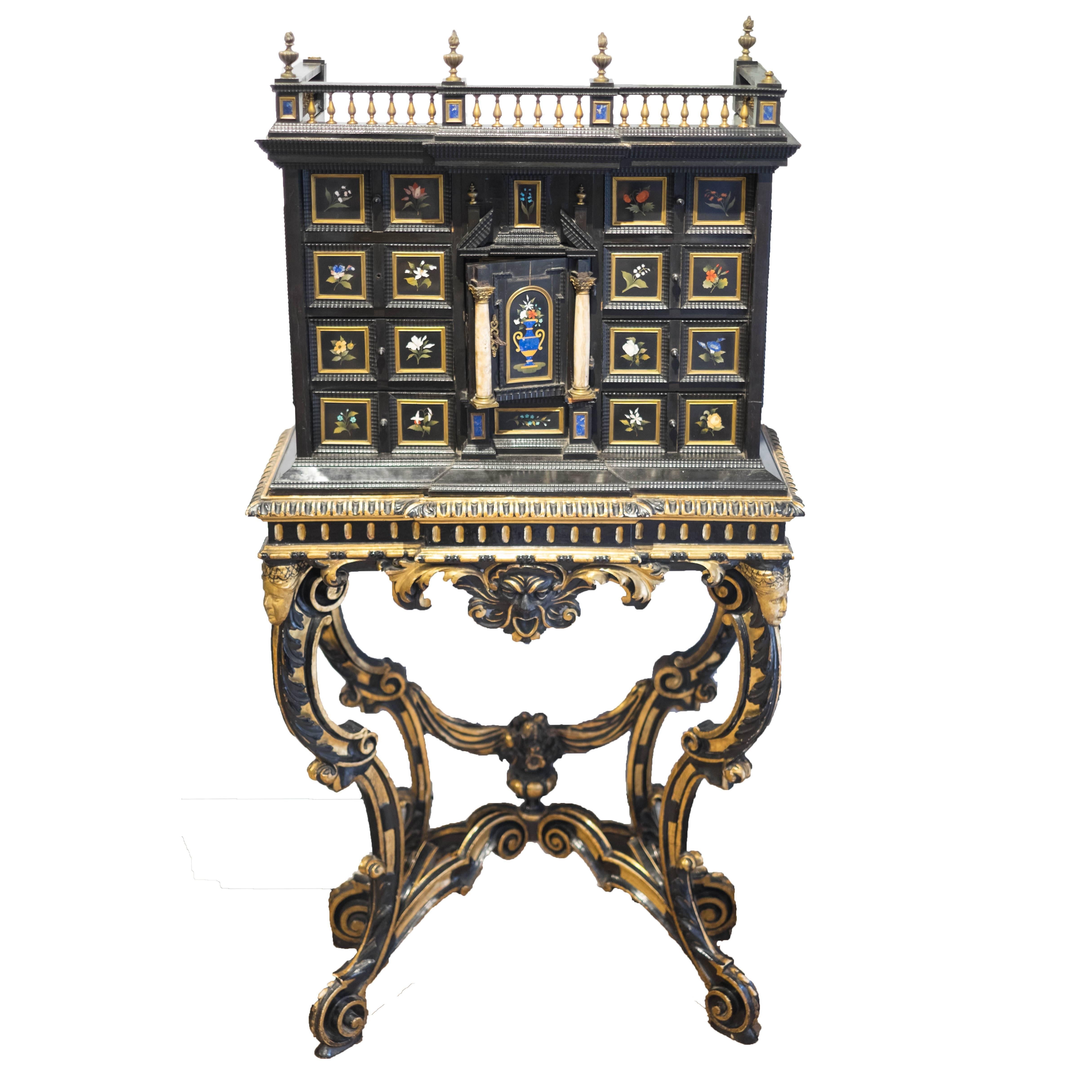 Pietra Dura florentine cabinet
Ebonised wood and giltwood base
Measures: H 62 in. (157.5cm); W 31 in. (78.7cm); D 14 in. (35.6cm)

Cabinet made of softwood with ebony veneer and rippled moulding. The door in the centre of the facade is decorated