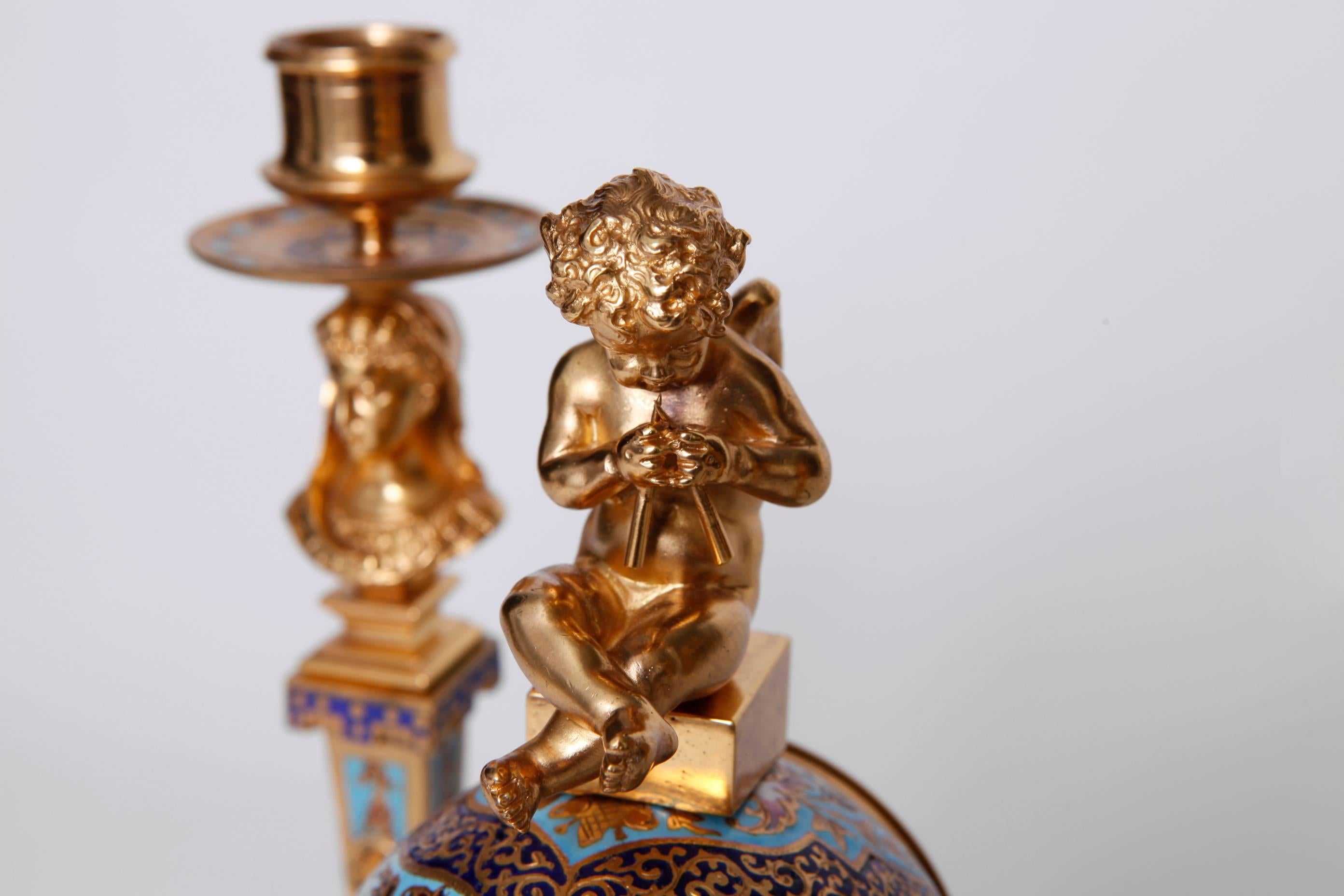 French Champleve Gilt Bronze and Enamel Clock Garniture
three piece set . Includes clock and a pair of candlesticks
Paris - France, c. 1880s

candlesticks - h 9.75 in; diam 4.5 in
clock - 10 in; Diam 3.5 in.
