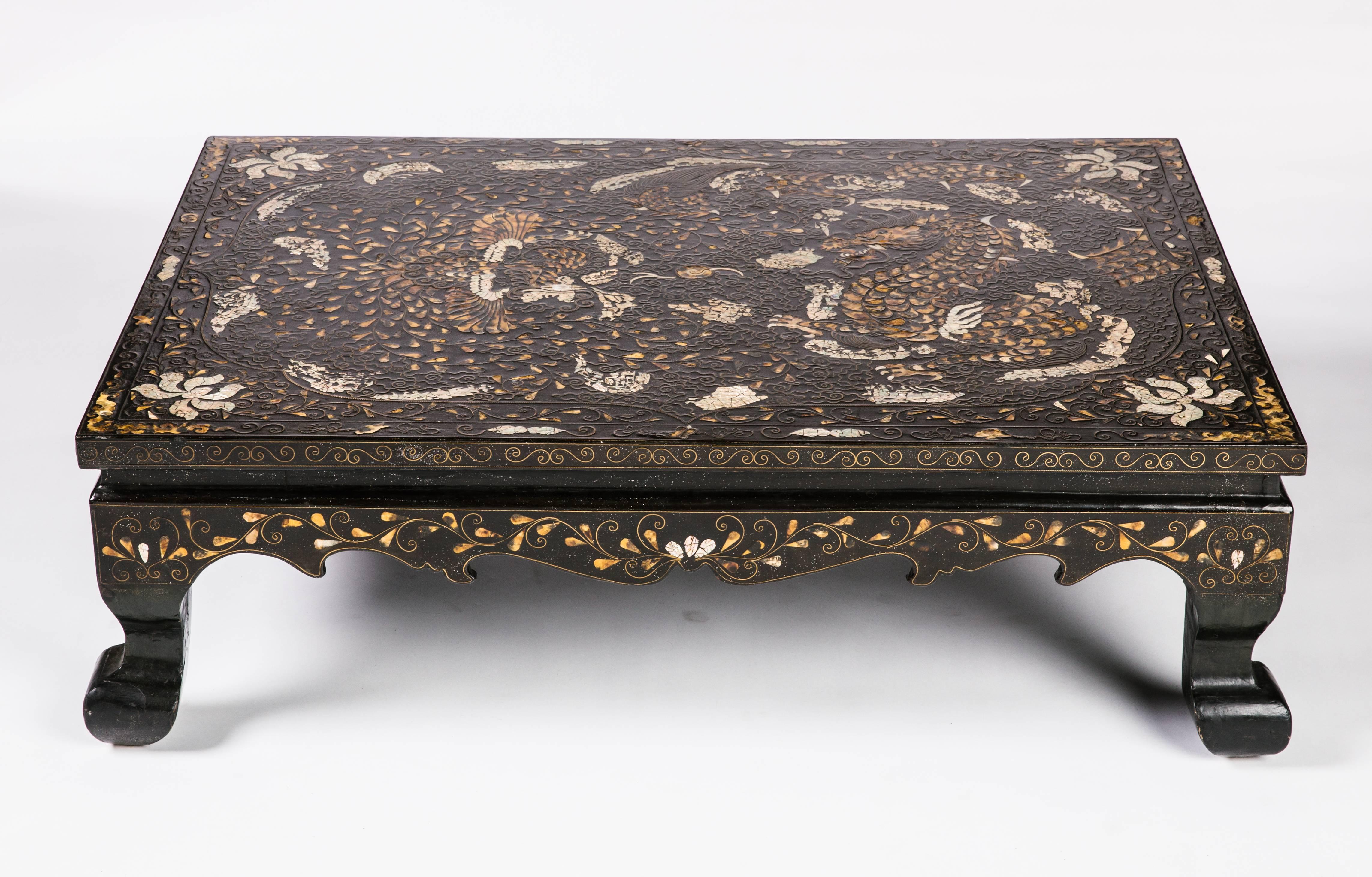 This is a Korean lacquered low coffee table with mother-of-pearl and brass inlay,
circa 19th century.
