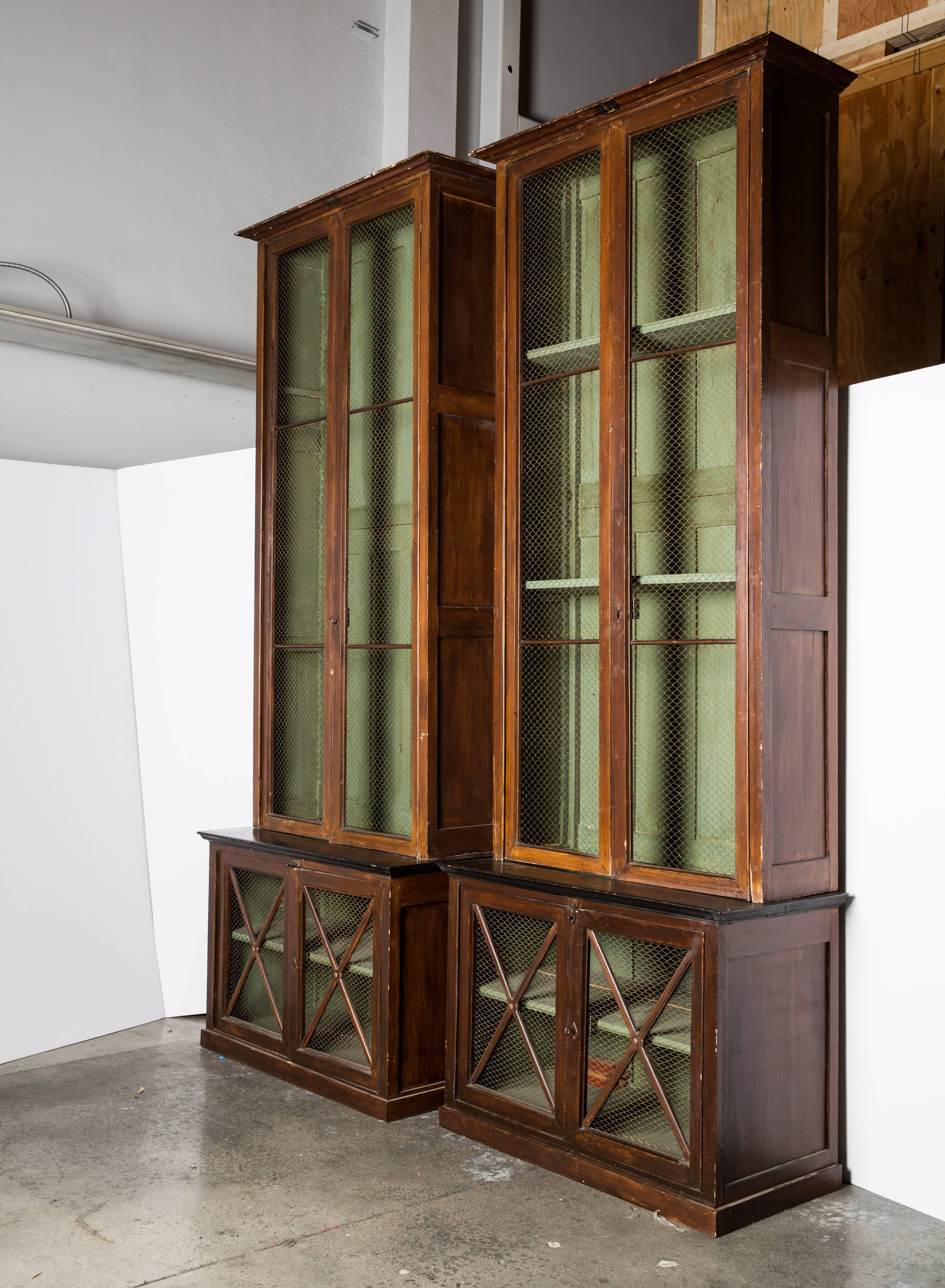 A massive pair of 19th century French painted pine bookcases with chicken wire fronts.