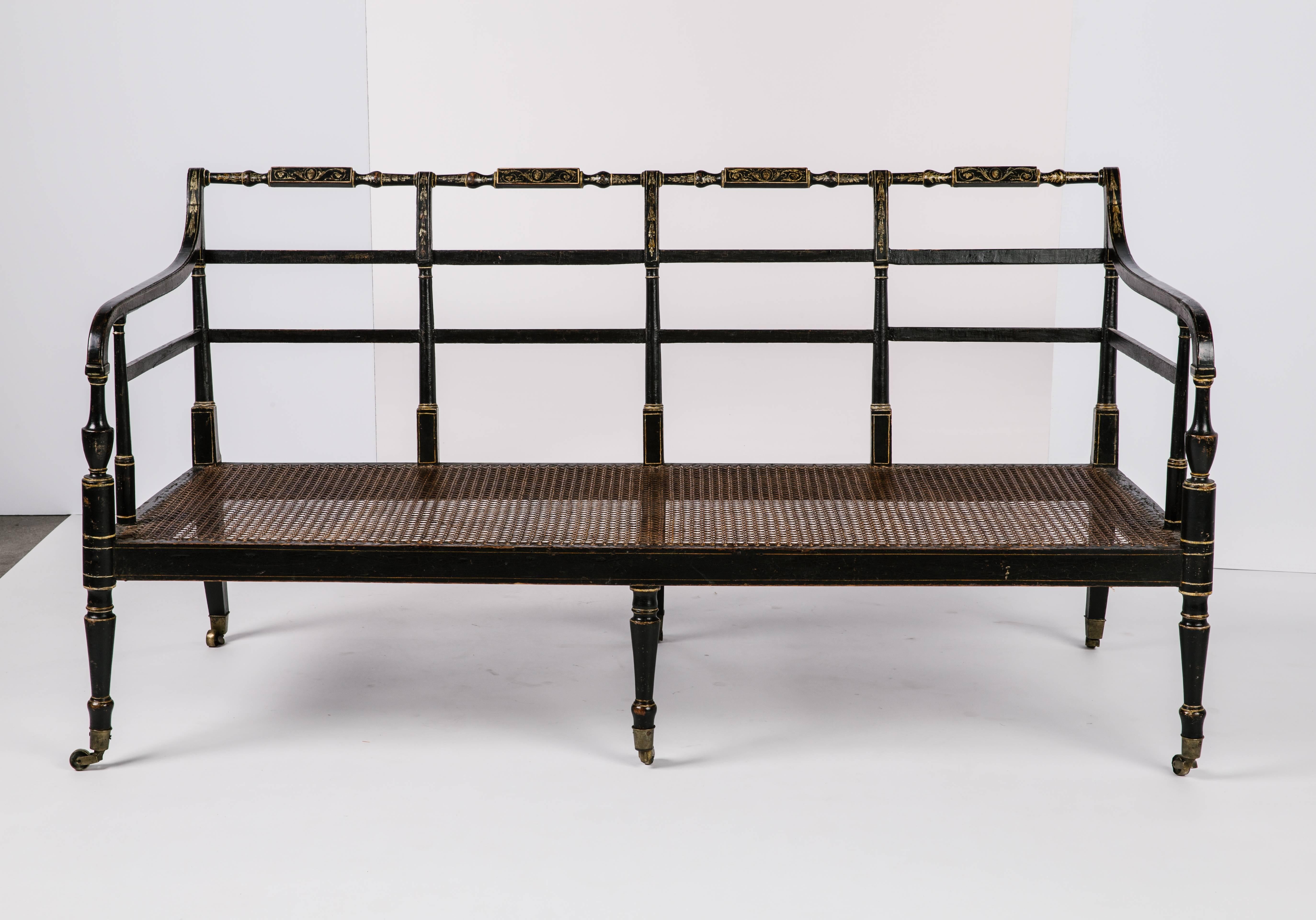 An early 19th century English Regency caned settee.