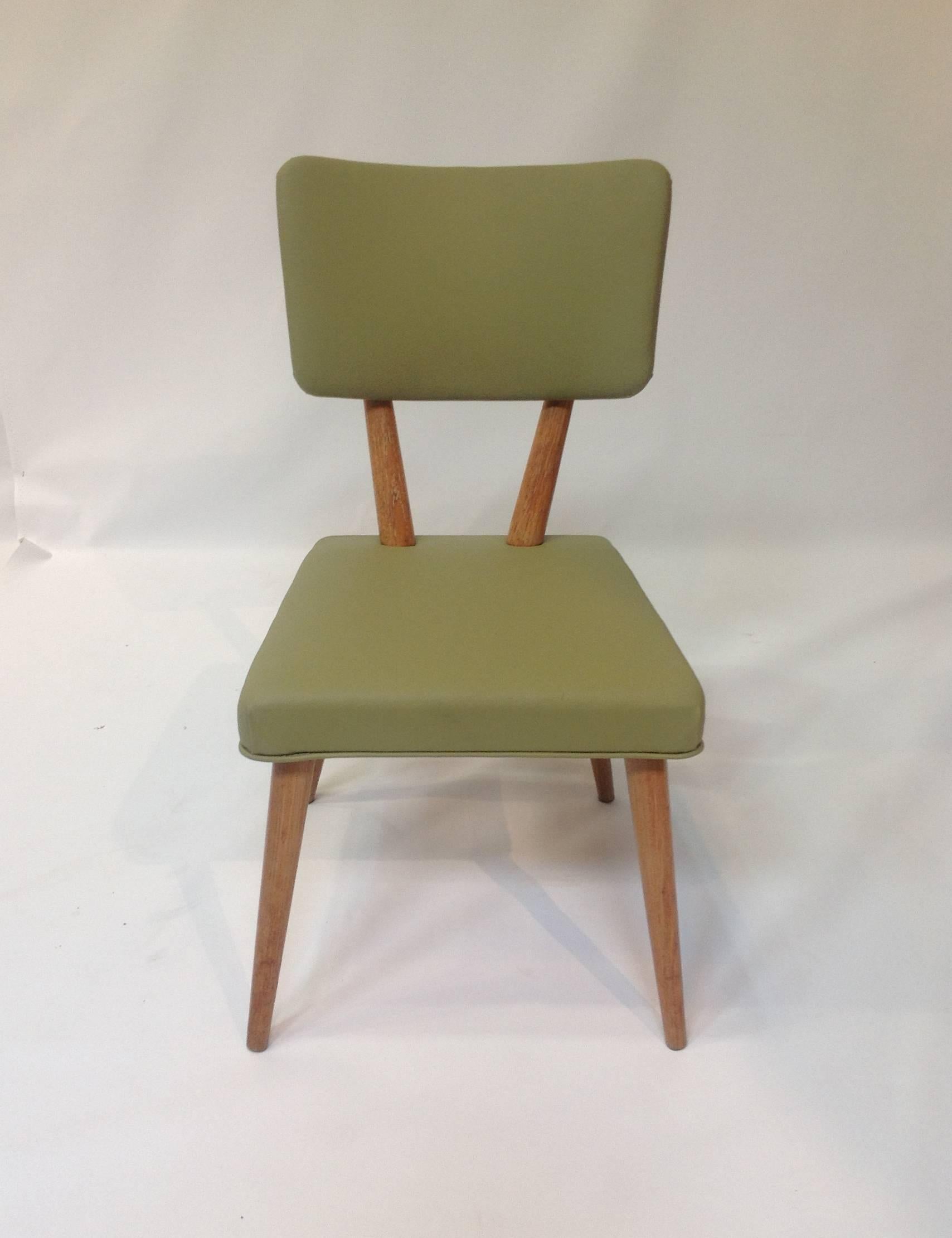 Newly re-upholstered in a beautiful green vinyl, these dining chairs have a classic, crisp, Mid-Century design. Manufactured by Meier & Pohlmann Furniture Co. in 1950.