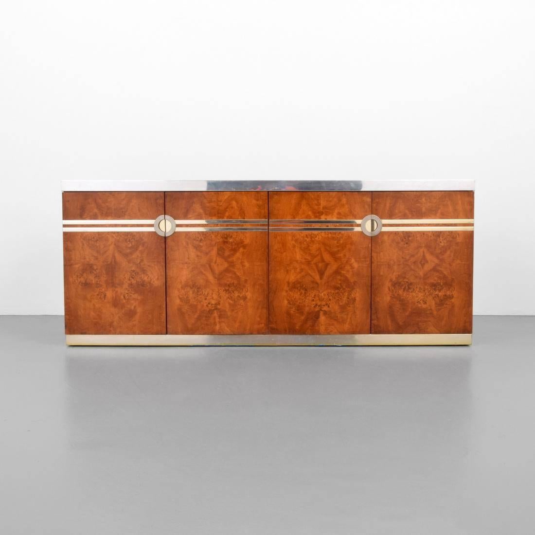 Beautiful Pierre Cardin burl maple credenza with chrome edges and small brass accent bands. Two doors reveal two drawers and a single shelf, the other pair of doors reveal an adjustable shelf. Signed on side.