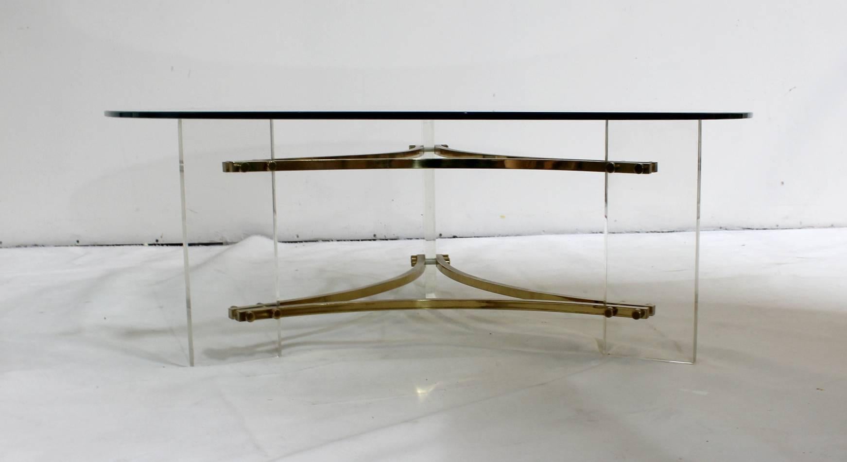 Brass and acrylic coffee table, circa 1980's. Designed by Charles Hollis Jones. 
Light wear to brass and lucite . Glass top is new and in great condition. 

Charles Hollis Jones is an American artist and furniture designer who is recognized by the
