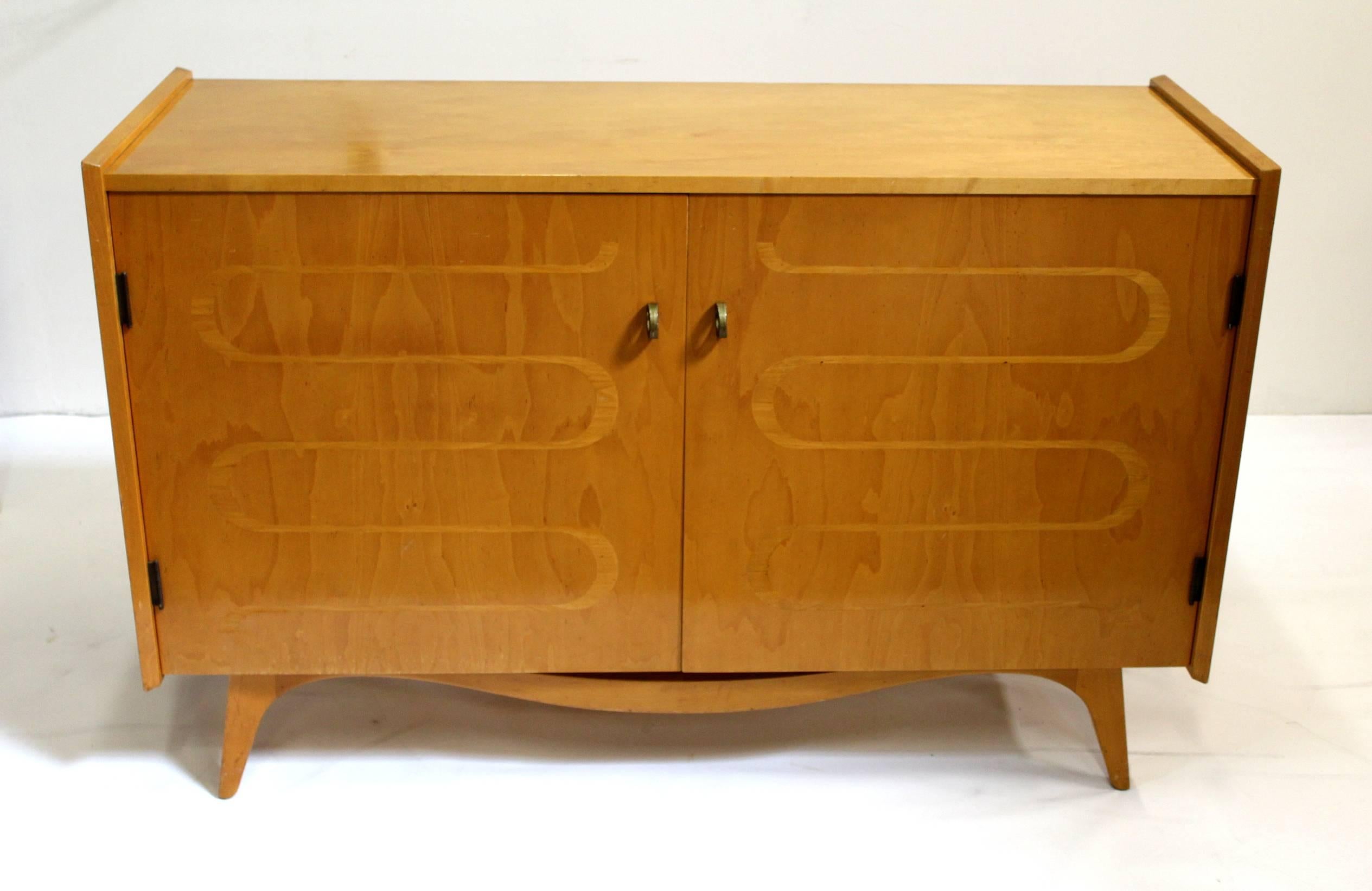 Classic Scandinavian Mid-Century design, dresser/chest with inlaid pattern on front doors, brass pulls and angled, tapered legs. Opens to reveal four shelves and eight drawers. Condition: Has small dings and scratches consistent with age, veneer