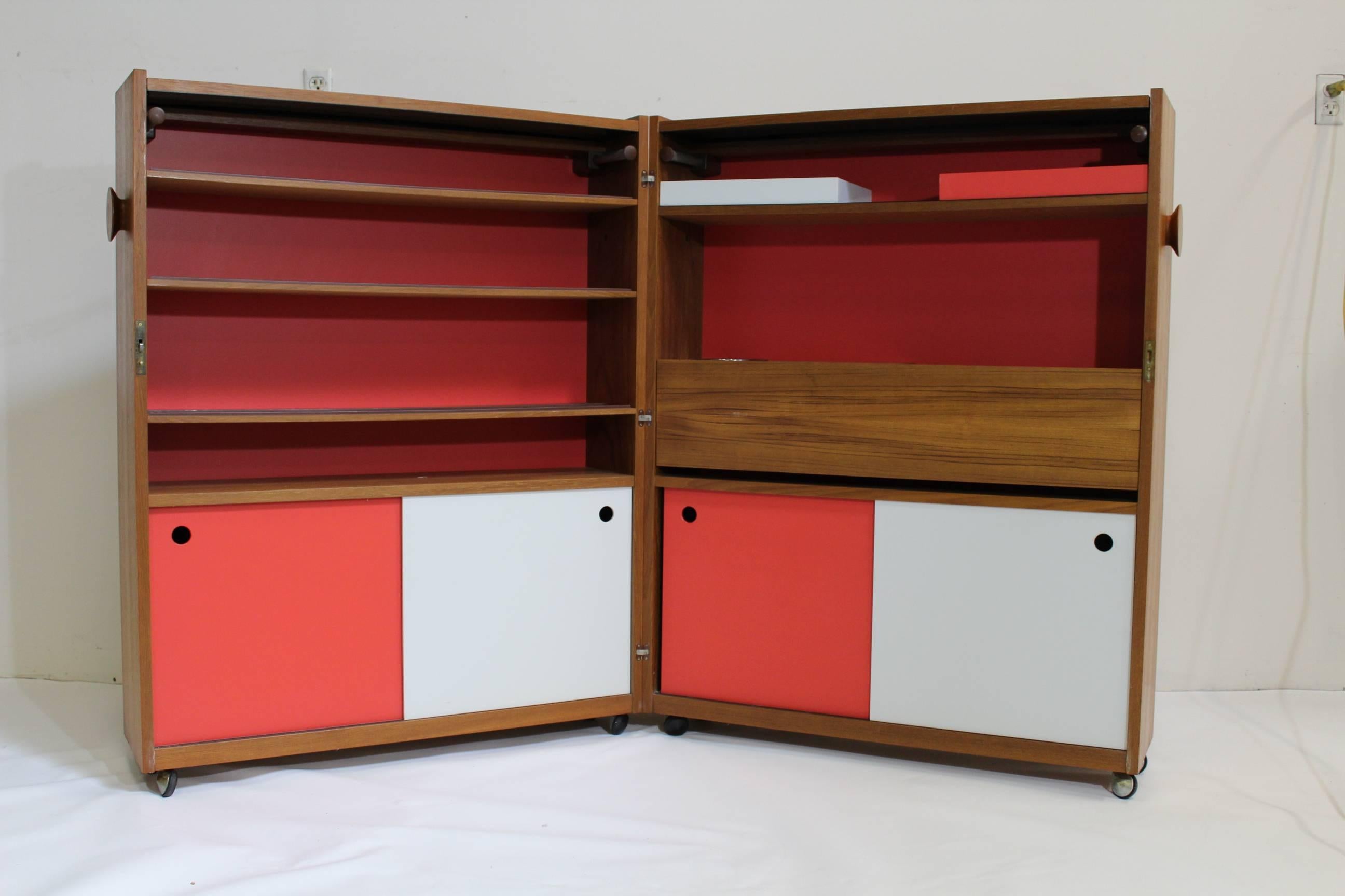 Vintage 1960s teak bar by Danish designer Erik Buch, opens up to reveal various compartments and storage shelves but can be closed to fit into a small space. The top flips up to reveal an extendable countertop for more of a bar feel. The teak has