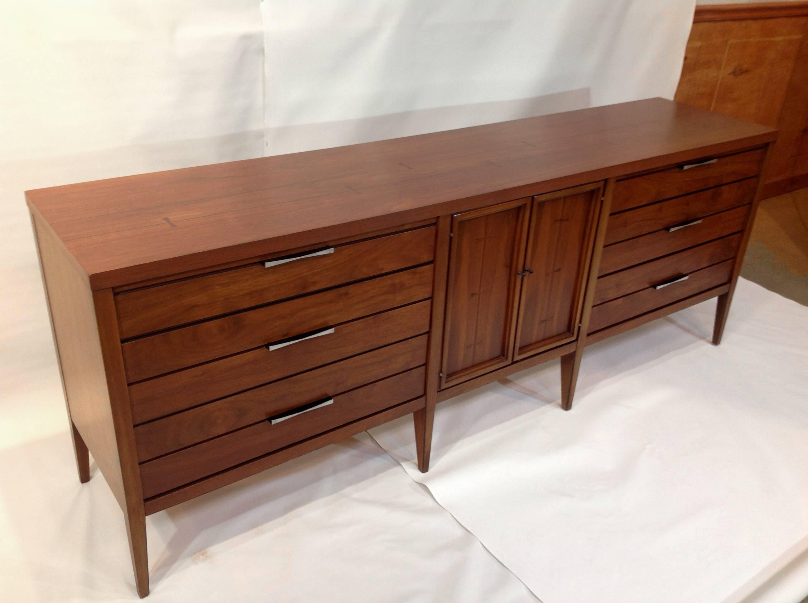 Large, exceptional Mid-Century walnut wood dresser manufactured in 1963, by American manufacturer Lane. This dresser is from the "Tuxedo" line and has little tuxedos inlaid in lighter wood across the top of the piece as well as on the