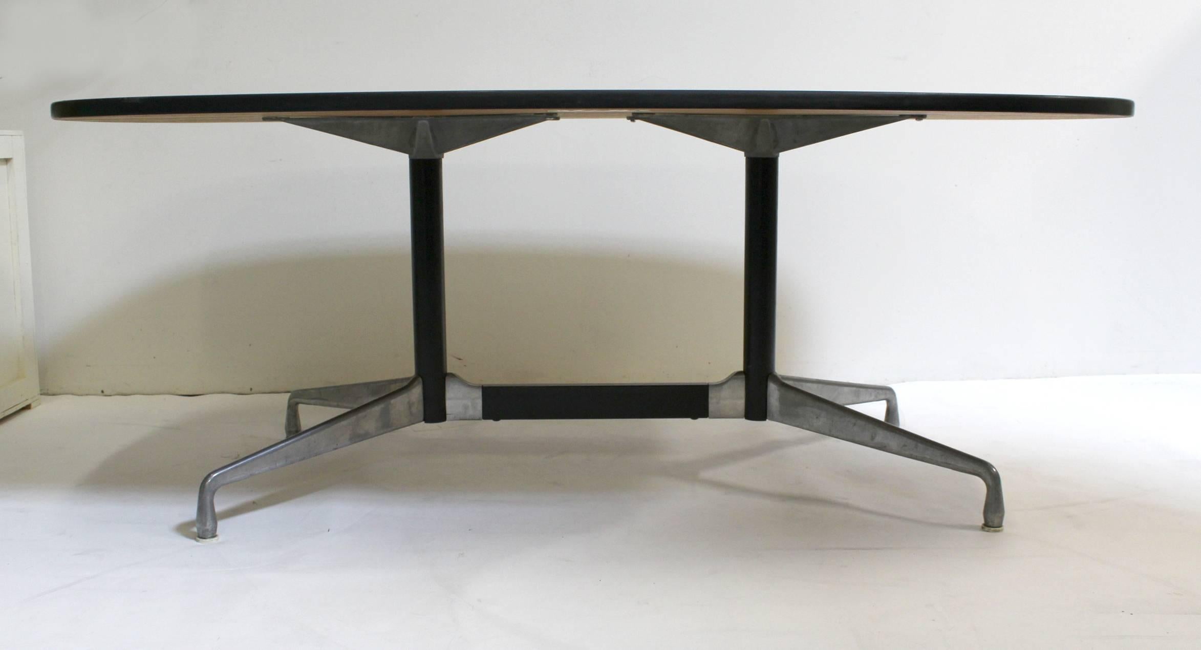Herman Miller laminate top conference or dining table with a segmented aluminum base designed by Ray and Charles Eames. Featuring a large dark walnut top set on a sturdy aluminum base. Original label is still on the underside.