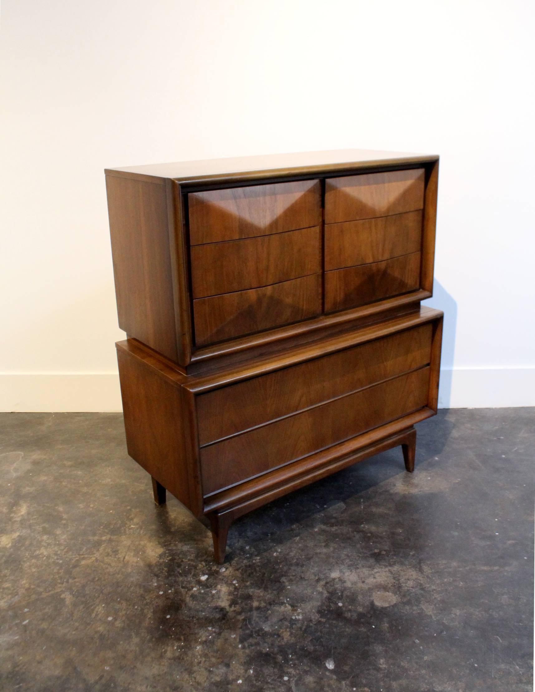One of the most iconic designs of the era! Beautiful beveled, diamond-shaped front with 6 deep drawers on top and two huge drawers on the bottom, glowing walnut wood, tapered feet.. Good condition: light wear with some larger nicks (see pictures). I