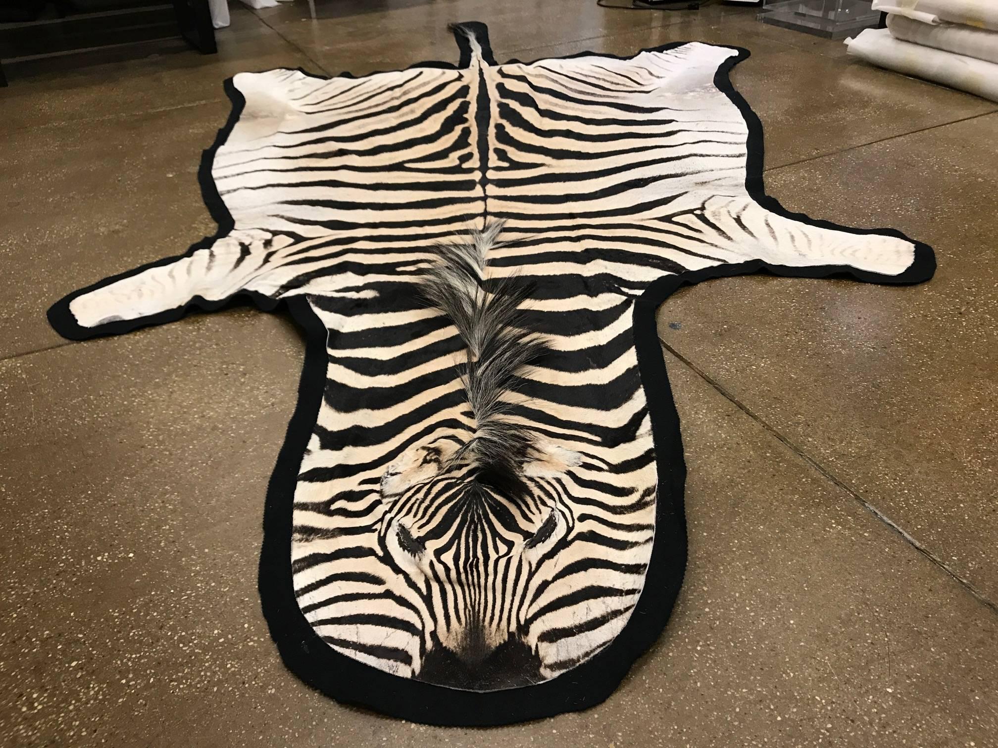 Beautiful grade “A” zebra skin rug lined with canvas and finished with leather trim.
Measures: 92'' x 59'' Long excluding the tail 
Large selection of hides of different qualities and sizes for rugs and upholstery.


 