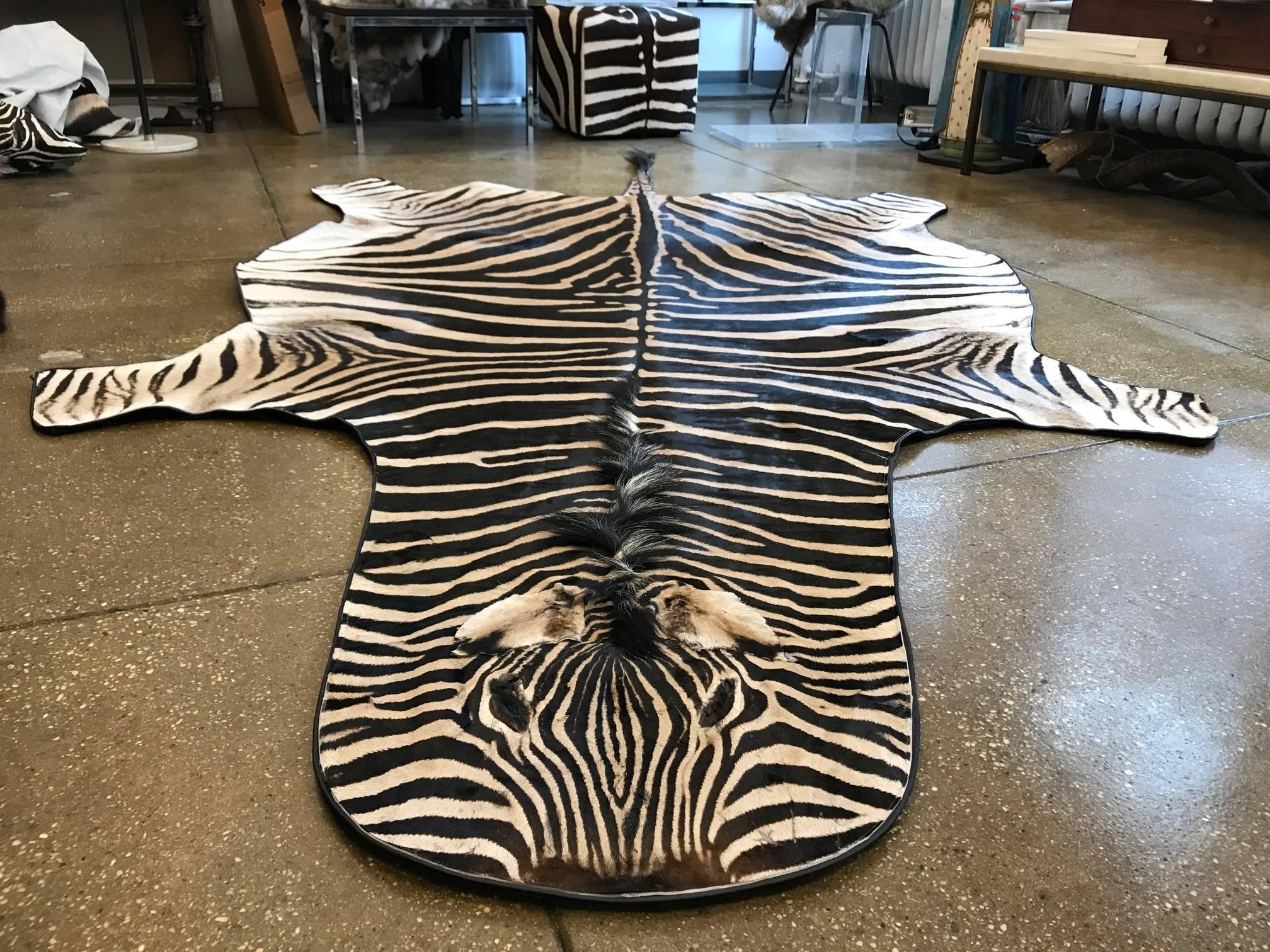 Beautiful grade “A” zebra skin rug lined with canvas and finished with leather trim.
Measures: 93'' x 60'' Long excluding the tail
Large selection of hides of different qualities and sizes for rugs and upholstery.