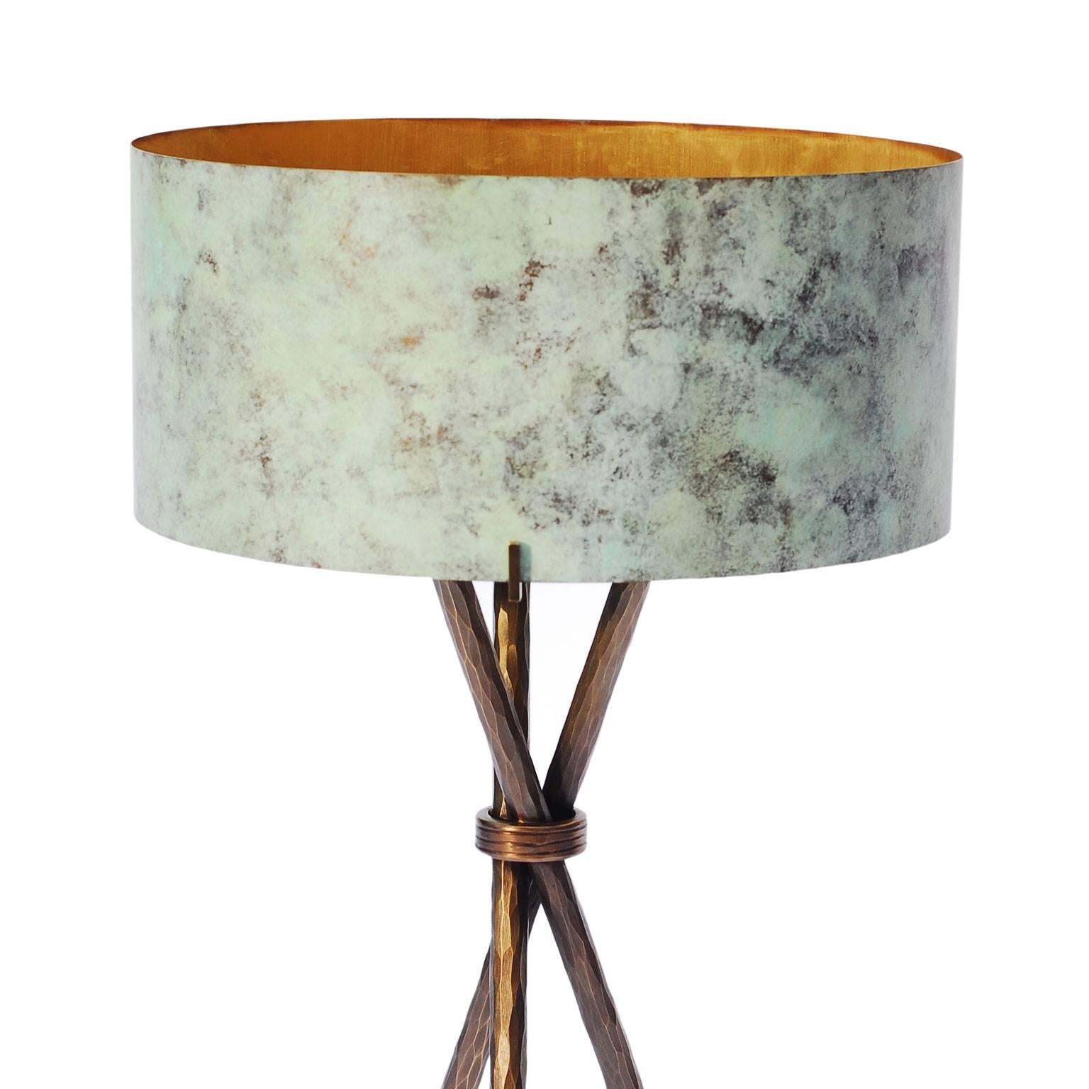 The entirely handmade table lamp has a hand-forged textured and patinated bronze base. The shade, as well, is in green patinated bronze.
 