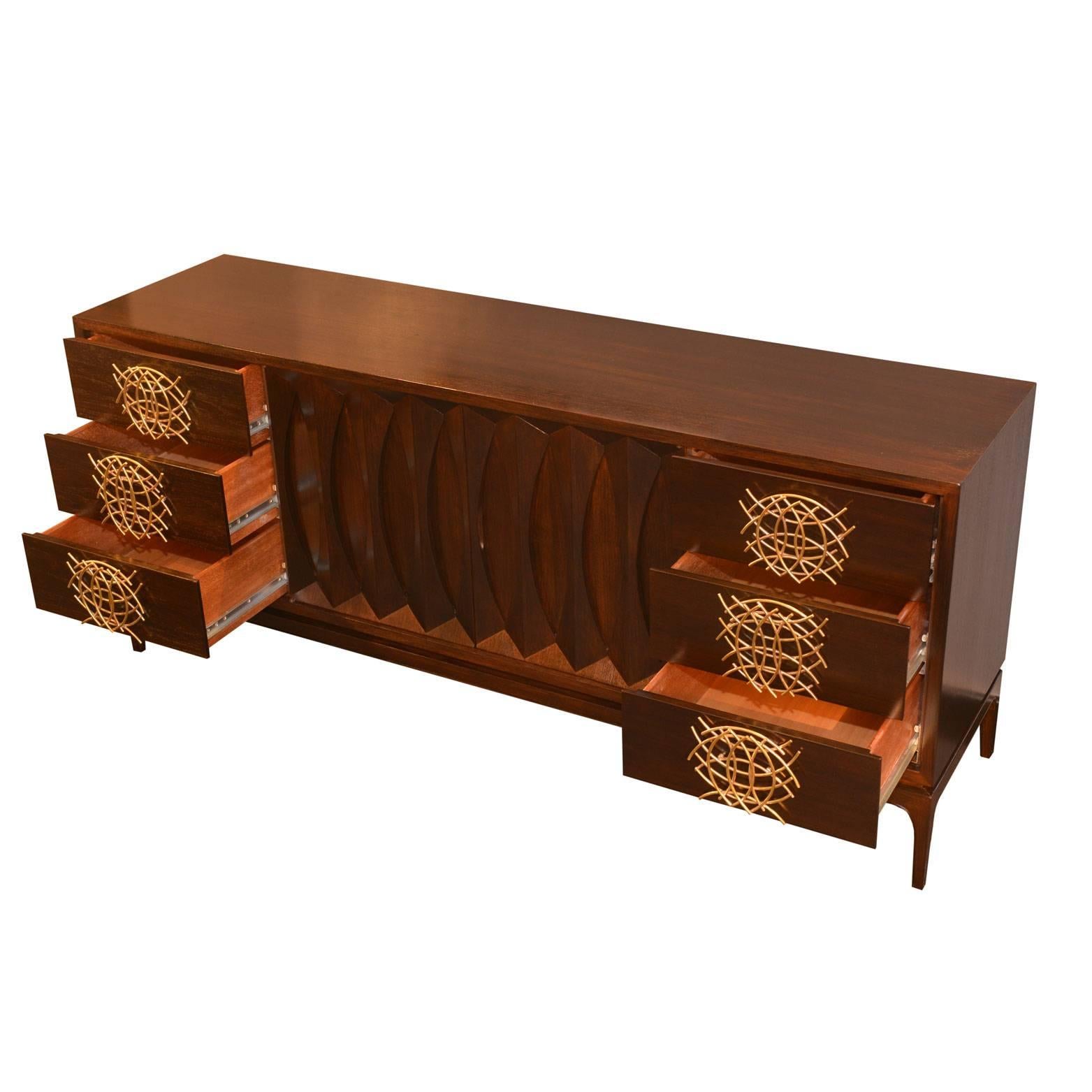 Stunning sideboard in darkened beechwood. The handmade brass handles replace the original wooden ones that were damaged. The style of the handles resembles the decorative motif of the central wooden doors.