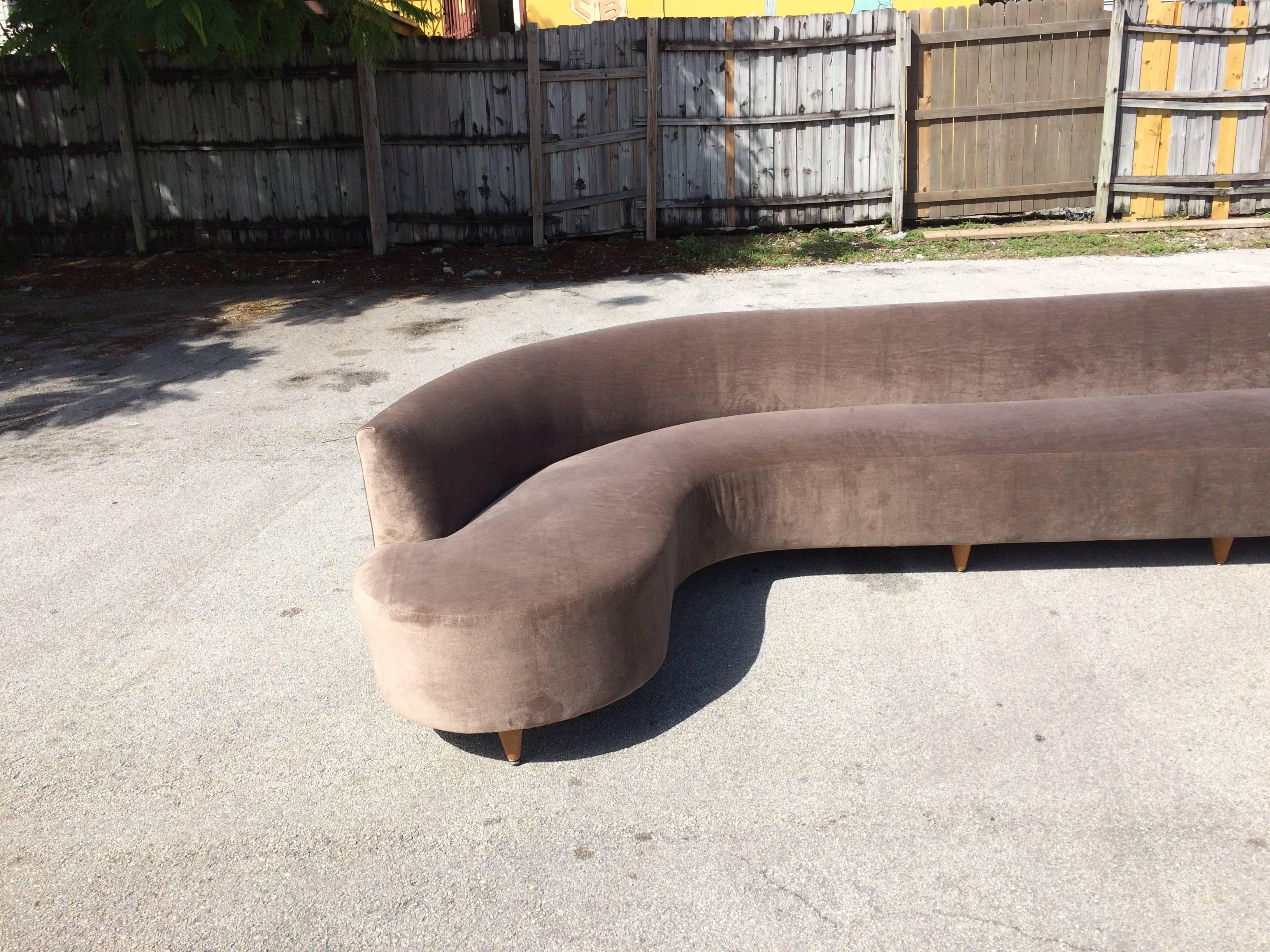 Large Sofa on eleven wooden legs. It seems to be a custom-made piece from the fifties. The sofa was at some point refinished.