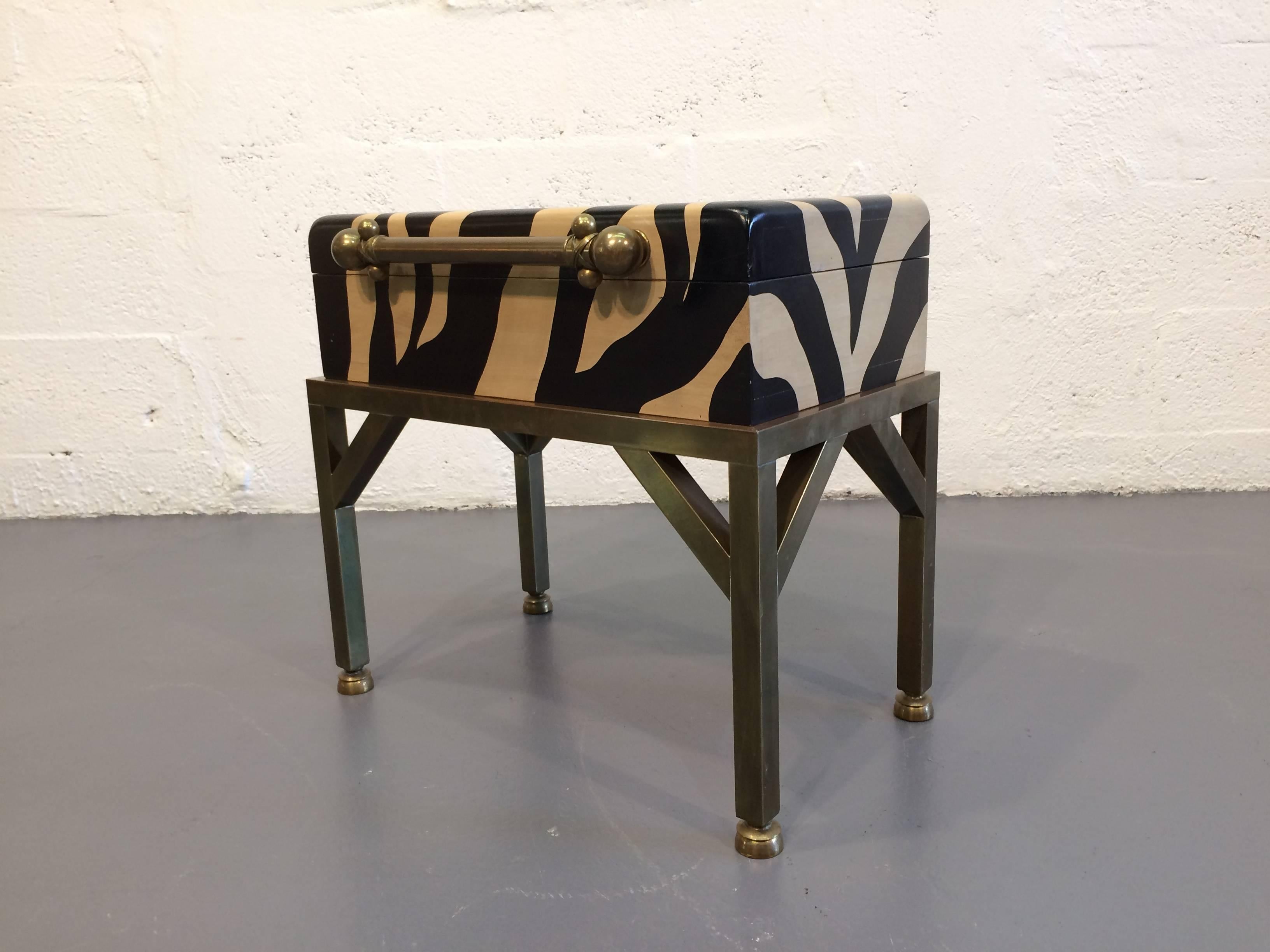 Trunk with a painted zebra pattern, hinged lid, brass handle and details.
Box can be removed from base.