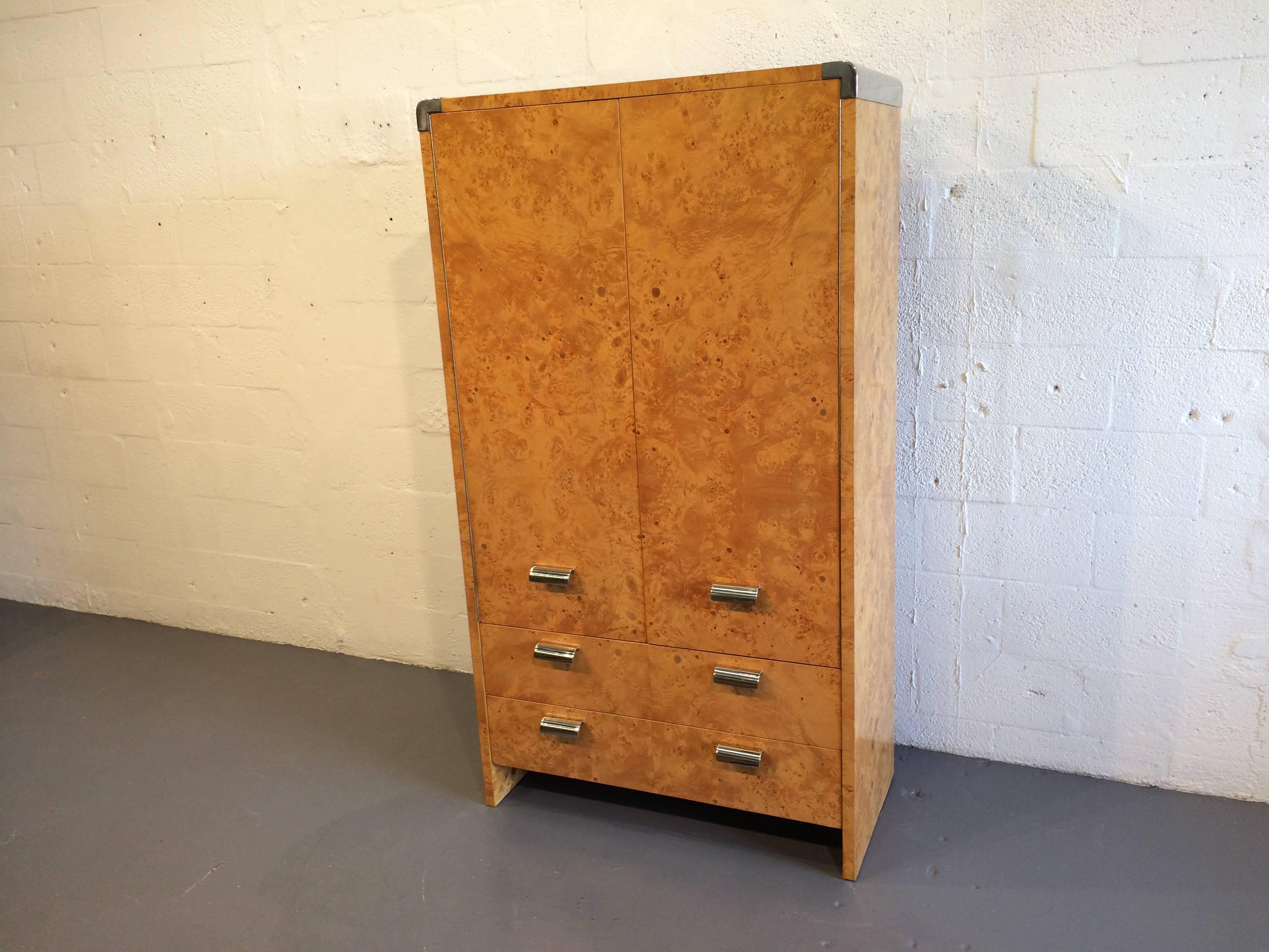 Burl and stainless steel tall dresser. Two doors and two drawers. Behind the doors are two shelves and three drawers.