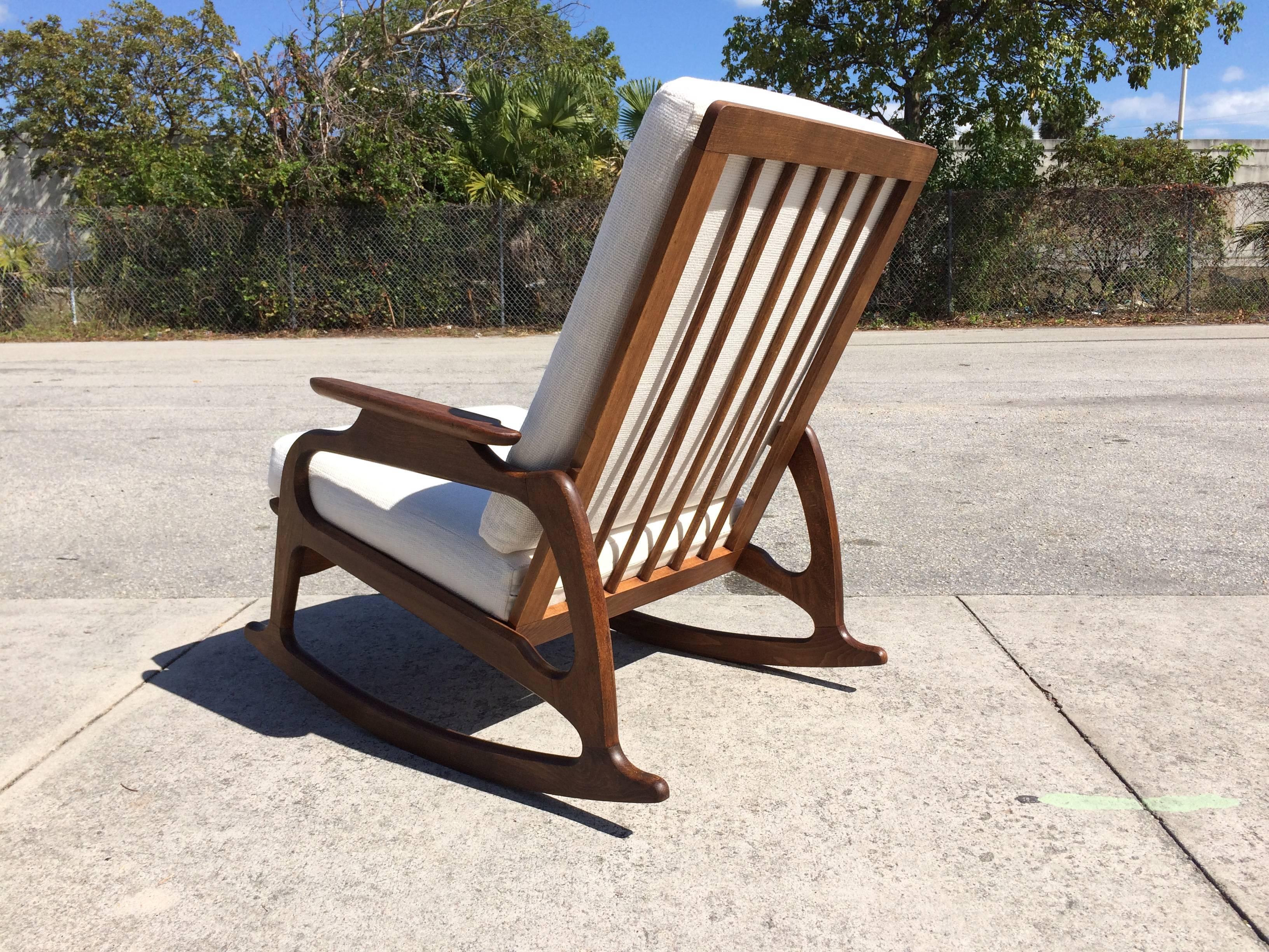 Solid wood construction with fabric cushions. Very cool retro rocking chair.