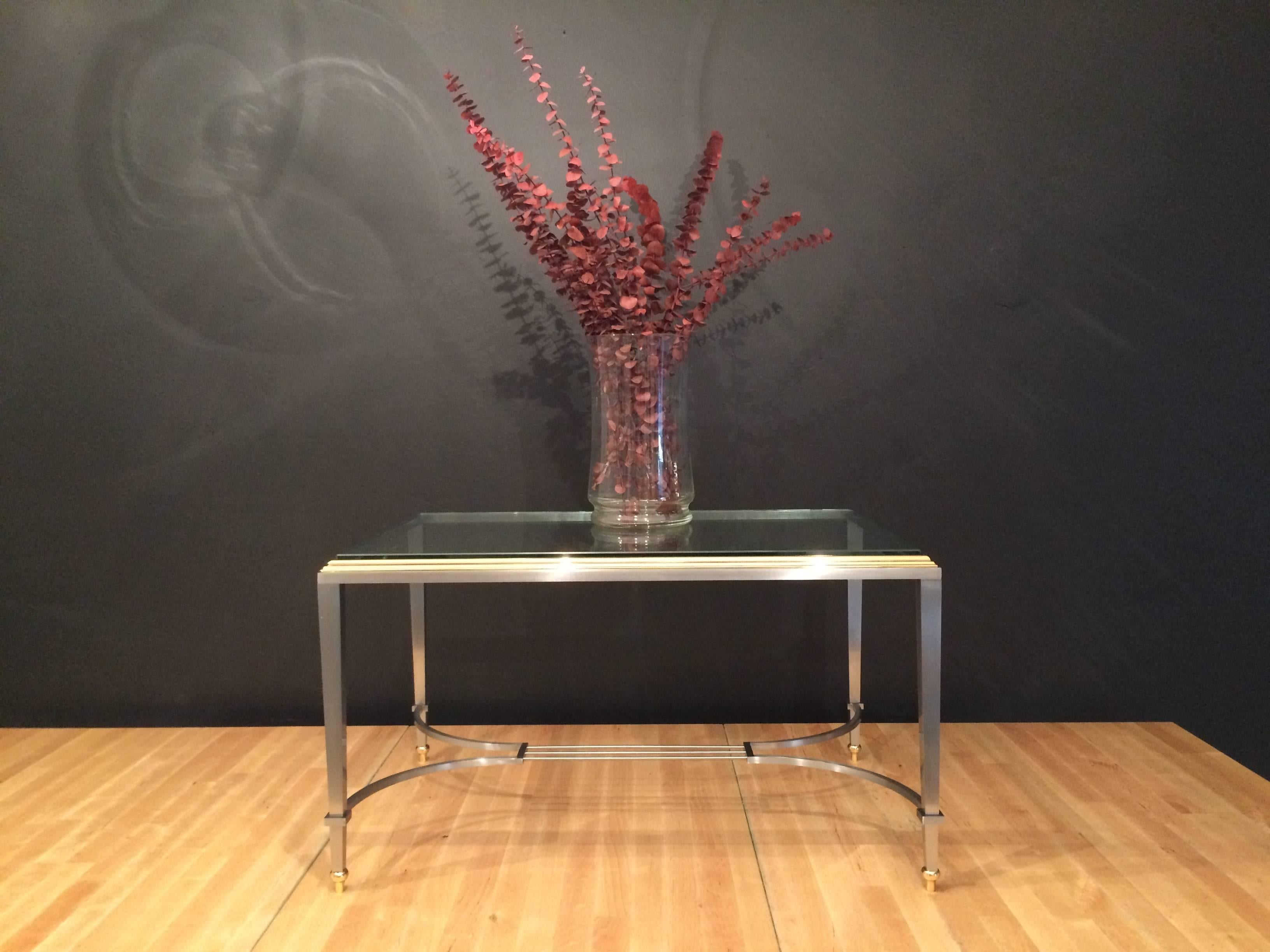 Tisch aus Messing und Stahl mit Glasplatte in der Mitte. Sehr gut gemacht und in gutem Zustand.