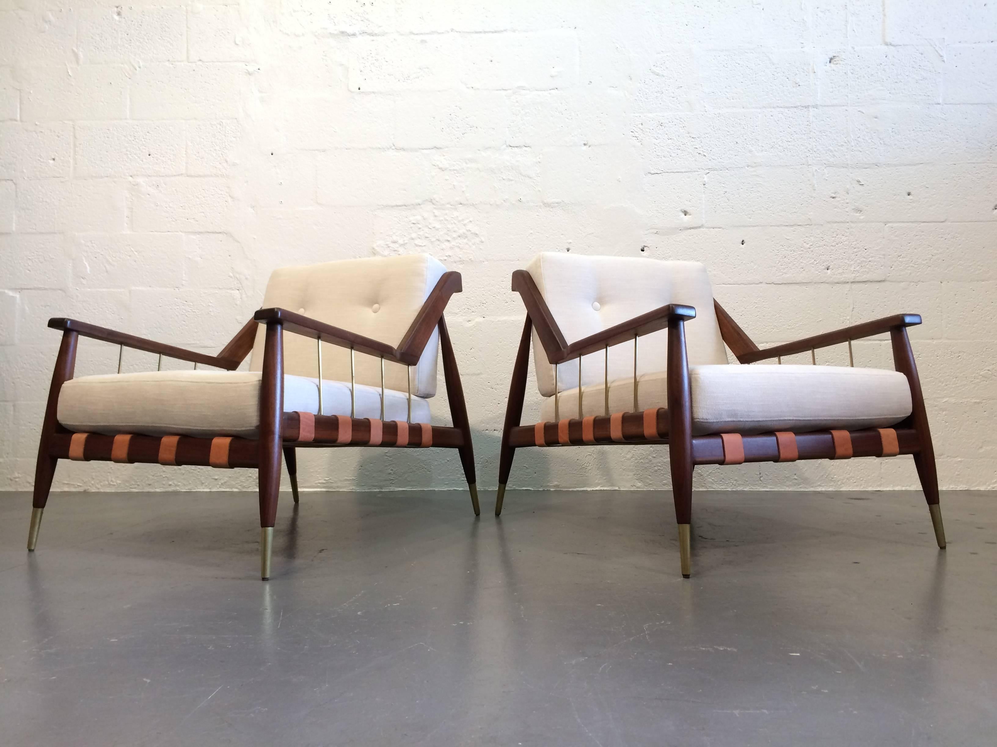 Beautiful lounge chairs, solid walnut frames with brass details, leather straps and fabric cushions.