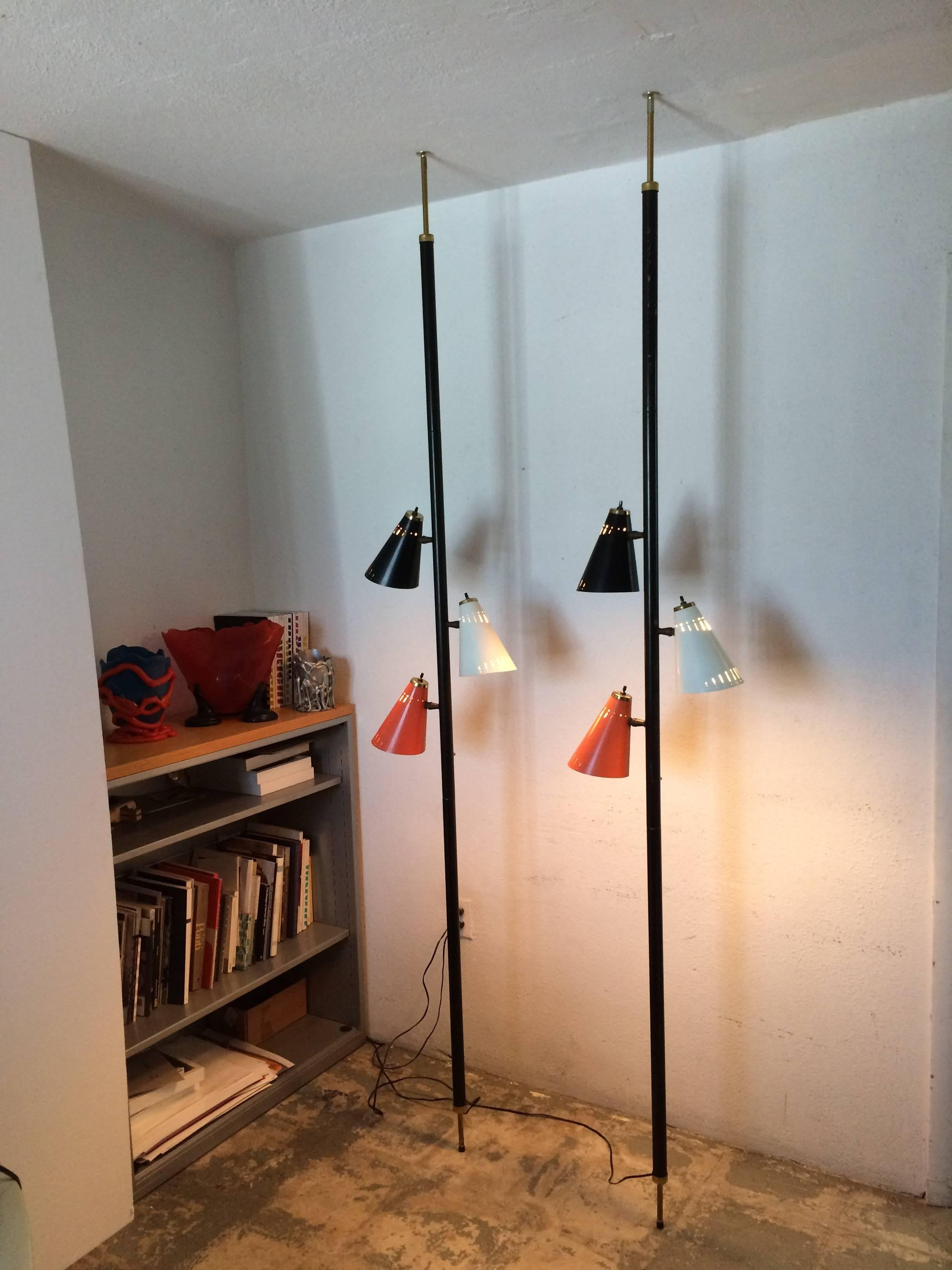 Beautiful pair of Pole Tension lamps. Pole in black and brass finish, shades are red, white and black. Designed for a 8ft ceiling. All original condition.