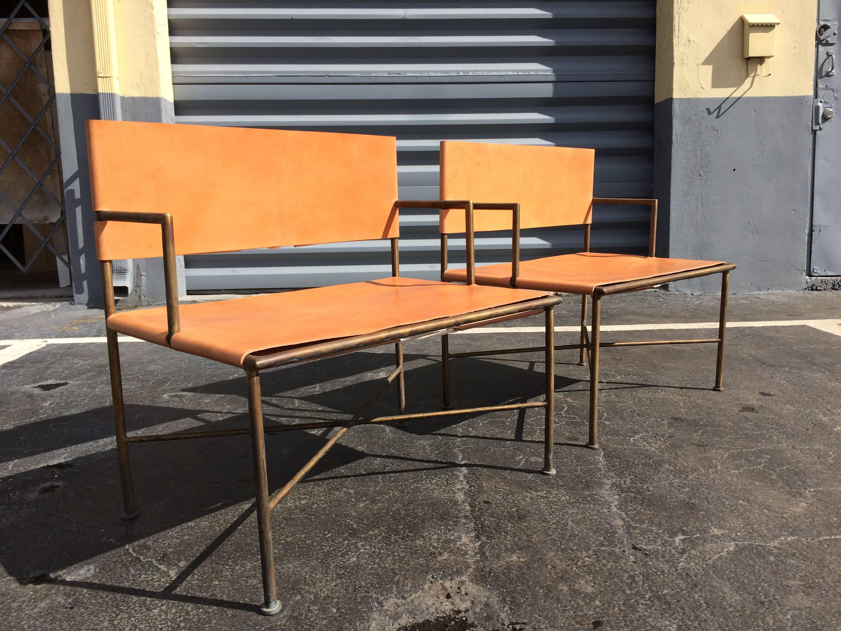 Bronze frames with saddle leather seats and backs.
Chairs are likely custom made, arm height of the chairs does not match.