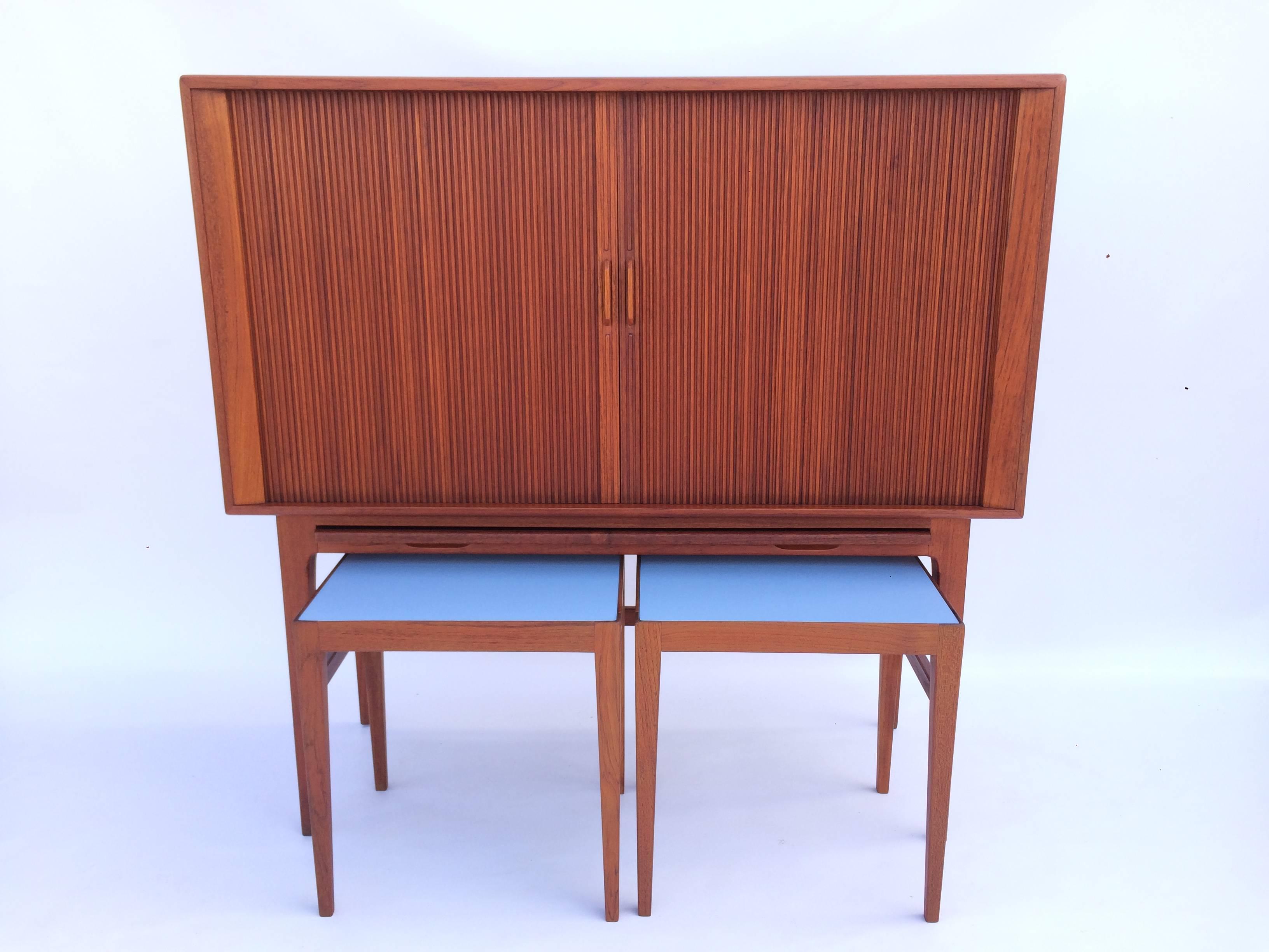 Teak Kurt Ostervig cabinet with matching serving tables for K.P. Mobler, Denmark. Wine rack and fixed glass shelves and a pull-out tray for mixing, completed by two serving tables. The two tables have light blue laminate tops.
The tables are 16.25