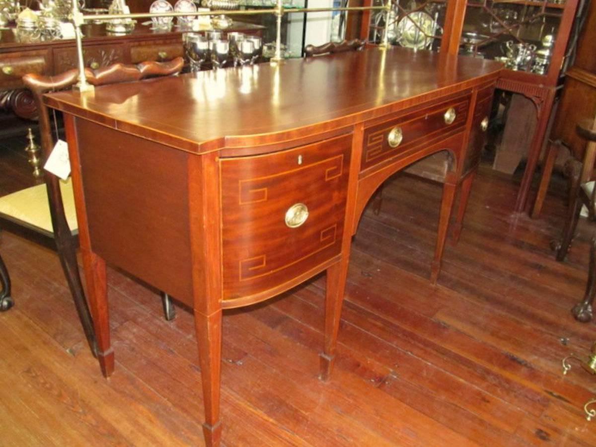 Superb quality antique English period George III inlaid mahogany Hepplewhite style sideboard with original brass gallery; right side cellarette drawer; wonderful boxwood line inlay throughout.

The handsome thistle motif oval brass pulls are