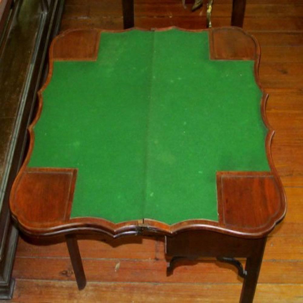 Very rare antique English mahogany period Geo. III triple folding shaped top card table.

This is a particularly rare triple folding games table with the first opening revealing a baize covered interior with four corner candle stands. The second