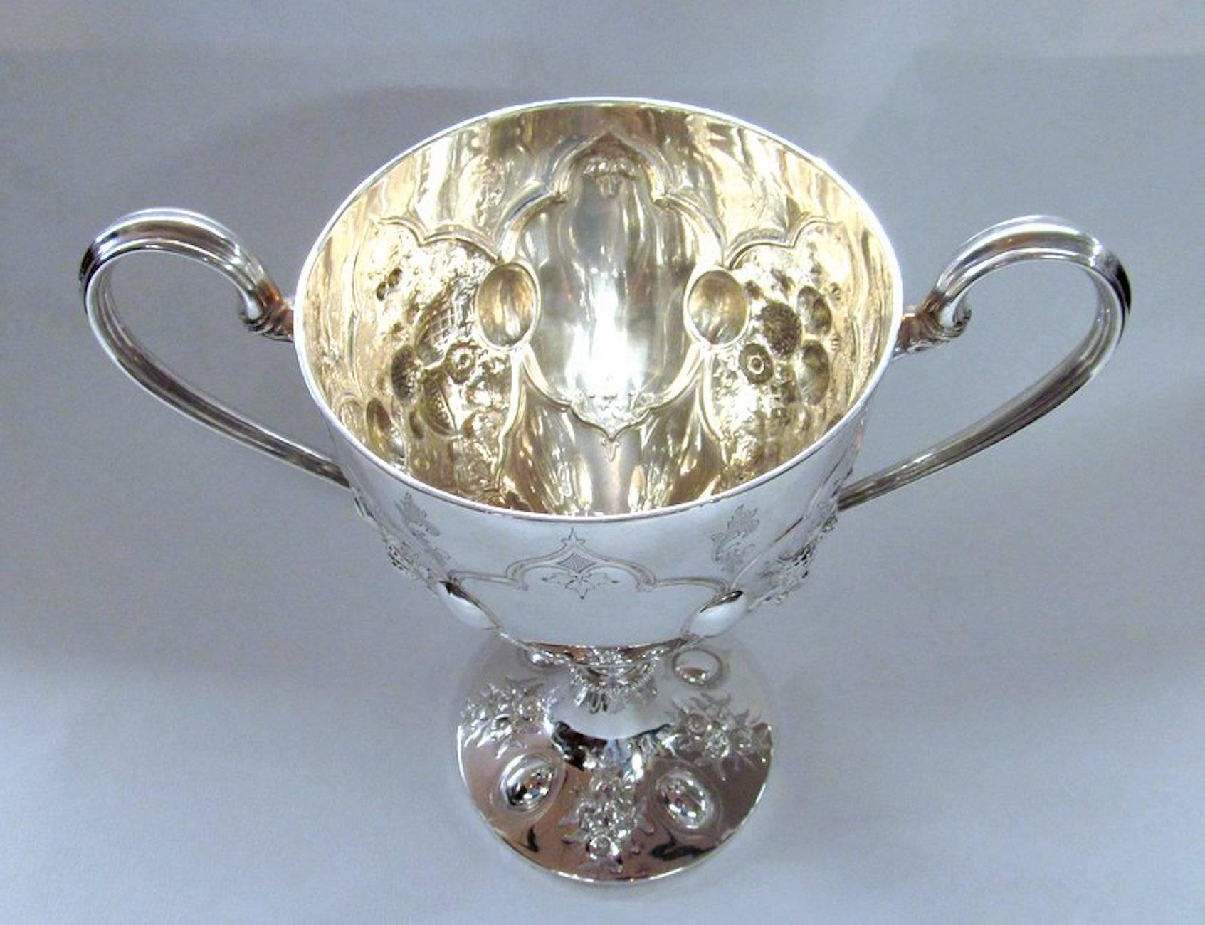 Fabulous large size heavy weight two-handle loving or trophy cup with engravable cartouche on either side (has never been inscribed).

Please note exceptionally hand chased strawberries and other fruit and leaves chased in bas relief.