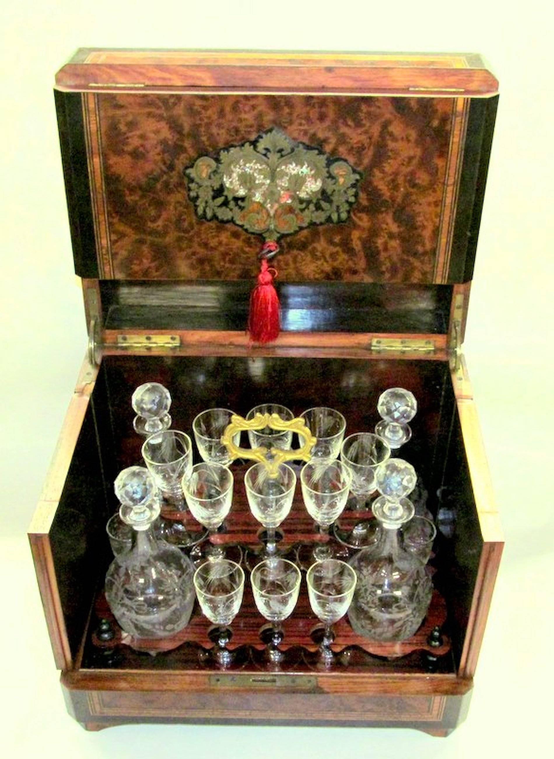 Rare and important exceptional quality antique French inlaid and ebonized amboyna and rosewood cave a' liqueur Tantalus set with engraved brass and pearl inlays with hand cut and engraved crystal decanters and glasses.

Set includes:

Four