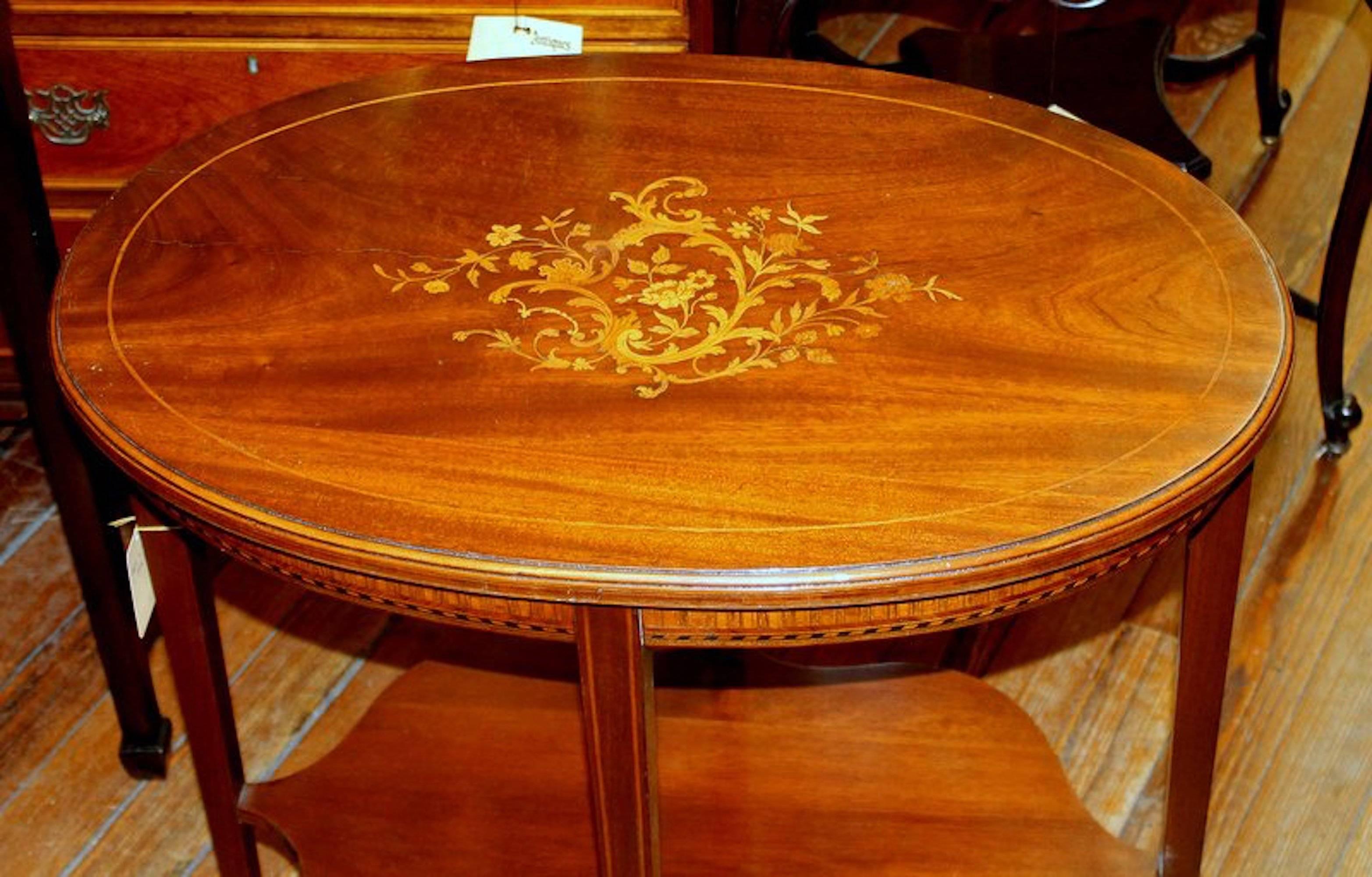 Superb old antique English marquetry inlaid mahogany oval table with delightful inlays around the apron and a handsome, shaped stretcher shelf. Pristine.
 