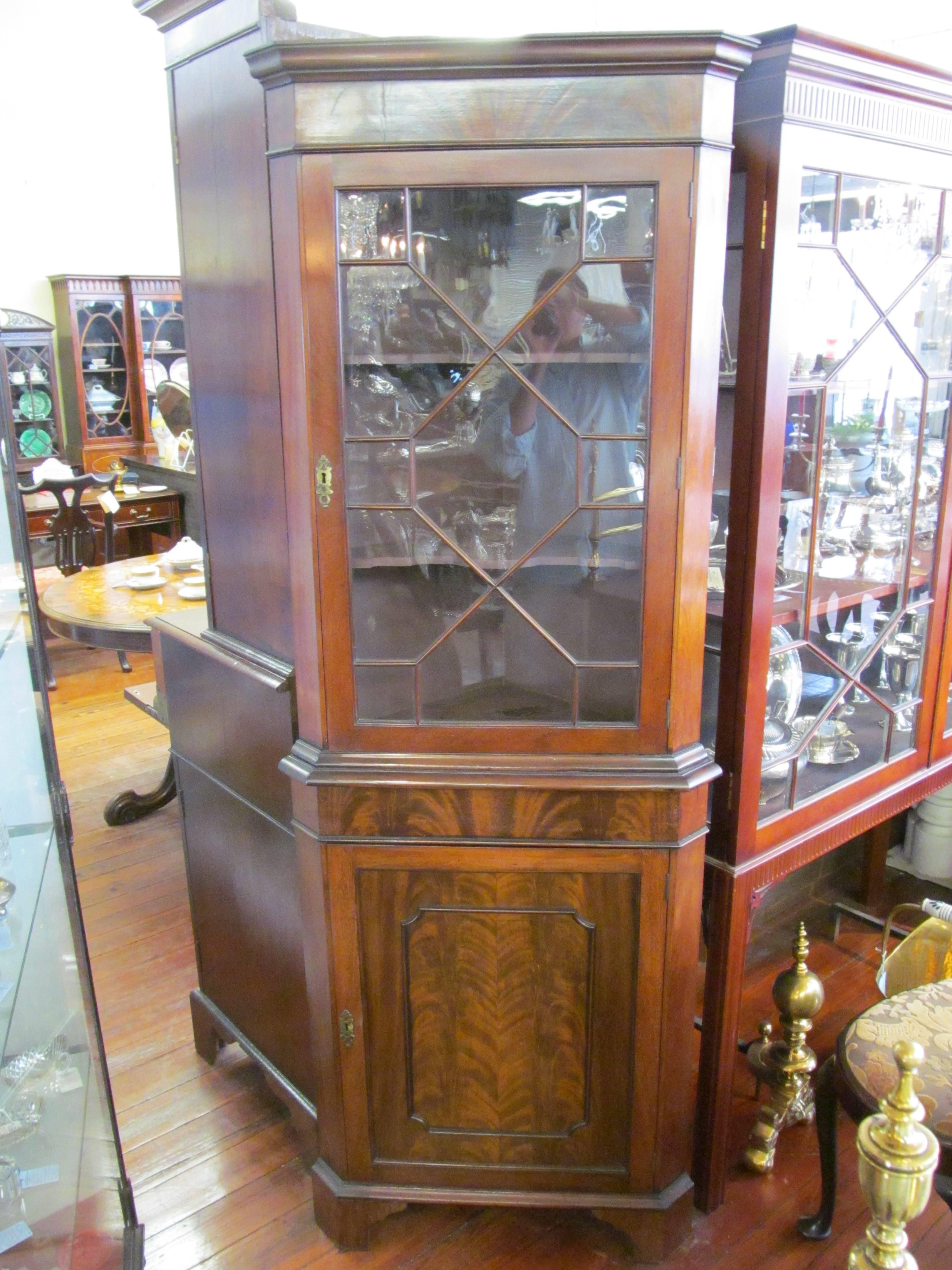 Fine quality Old English flame mahogany Chippendale style corner cupboard; lovely glazed upper door which reveals interior shaped front shelves. Please note the superbly bookmatched flame or crotch mahogany along the front,

circa 1910-1920.