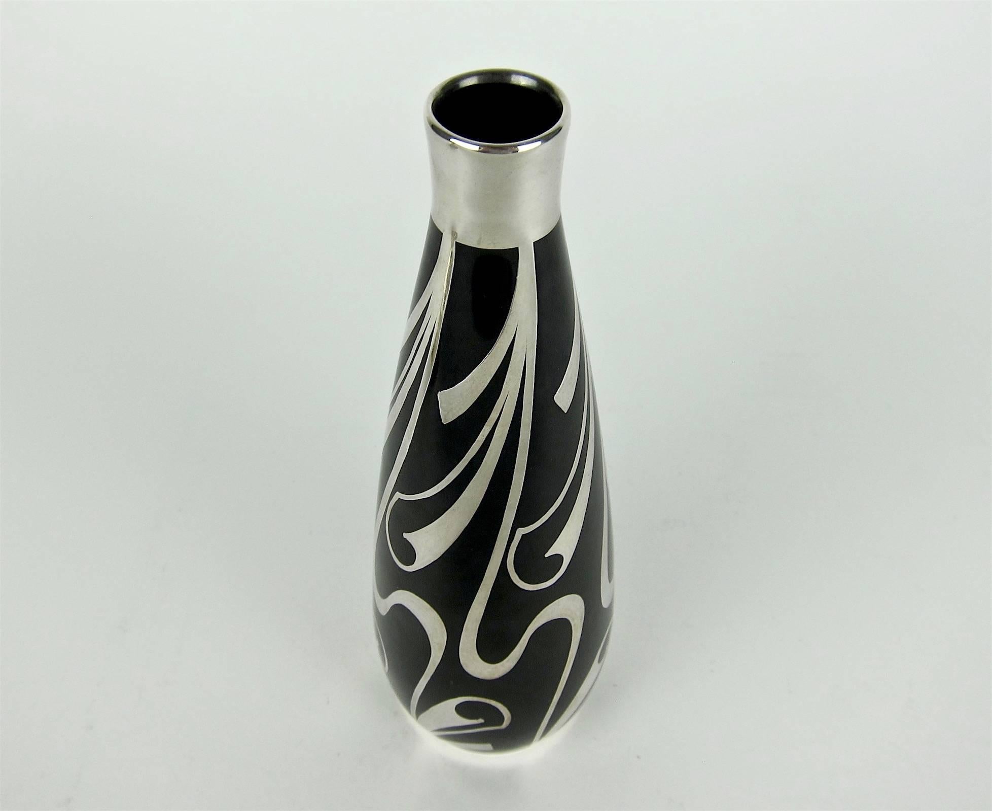 A Mid-Century black vase in fine Hutschenreuther porcelain with a contrasting overlay of sterling silver by Spahr & Co./Silberbelegwaren-Fabrik of Germany. Friedrich Wilhelm Spahr decorated this stylish vintage vase with swirling and scrolling