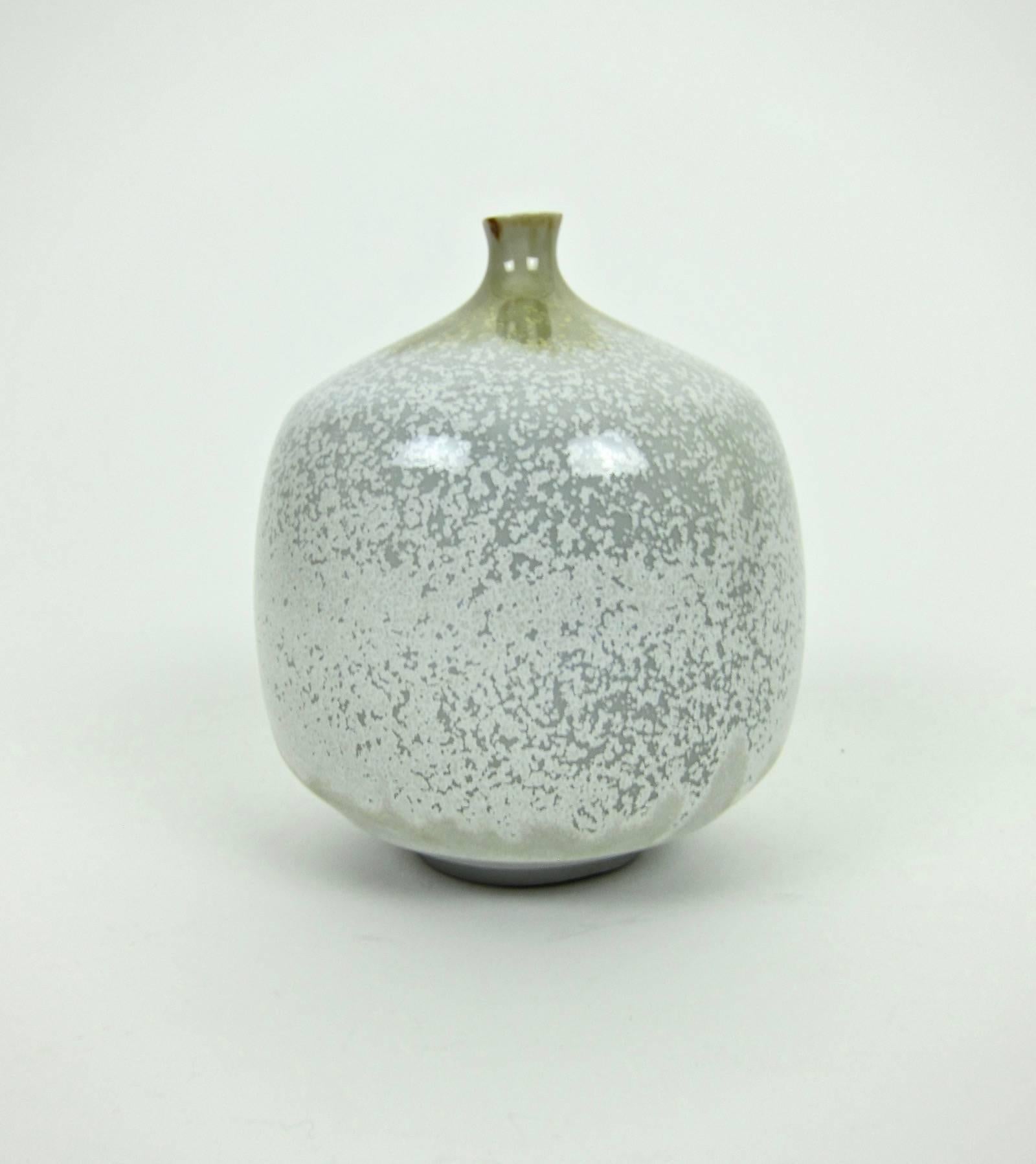 A Mid-Century porcelain weed pot vase decorated with sophisticated glazing techniques in neutral tones, signed Ostone underfoot. 

The top of the vintage vase is decorated with a glossy flambe glaze in earthy shades of green and brown while the body