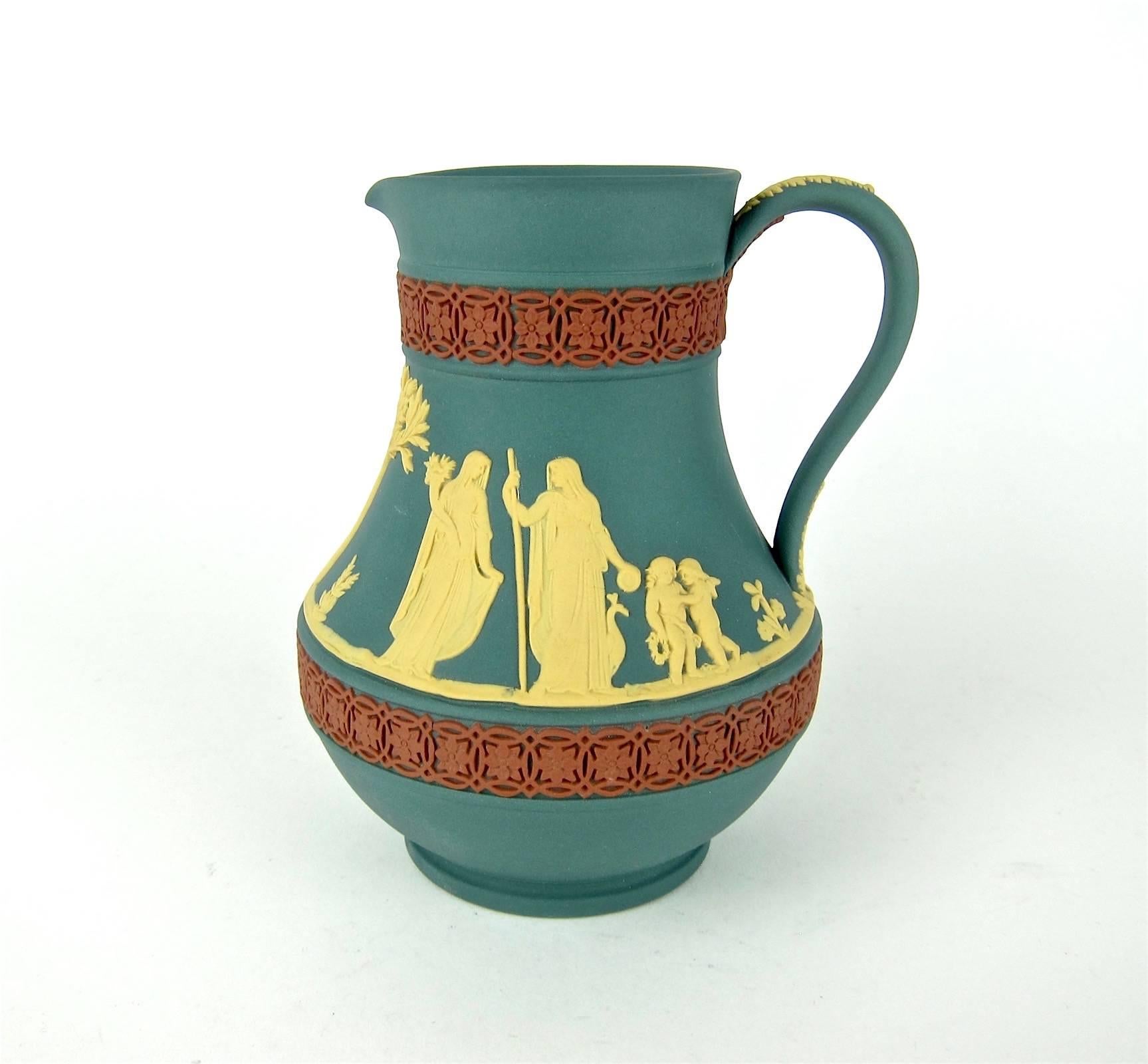 A vintage tricolor 'Etruscan' jug in teal, cane and terra cotta jasper ware from Wedgwood of England. The limited edition pitcher was introduced in 1986 to celebrate the opening of the Wedgwood boutique at Higbee's in Cleveland. The vessel comes