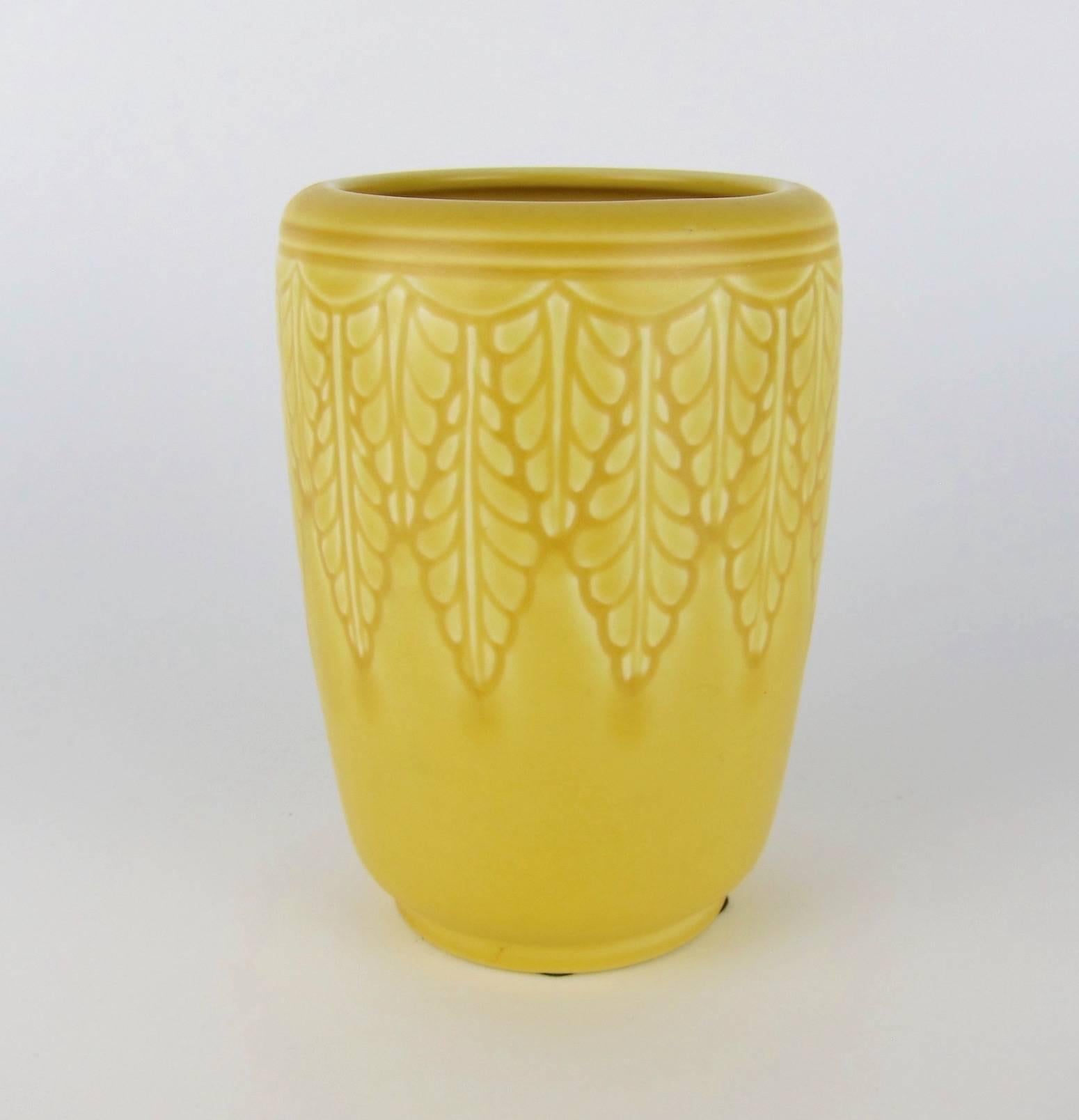 A vintage Rookwood Pottery production vase made in 1938. The American Arts & Crafts style vessel features molded foliate decoration glazed in sunny matte yellow. 

Very good condition, measuring 6.25 in. H x 4.25 in. Dia. (at widest). Rookwood's