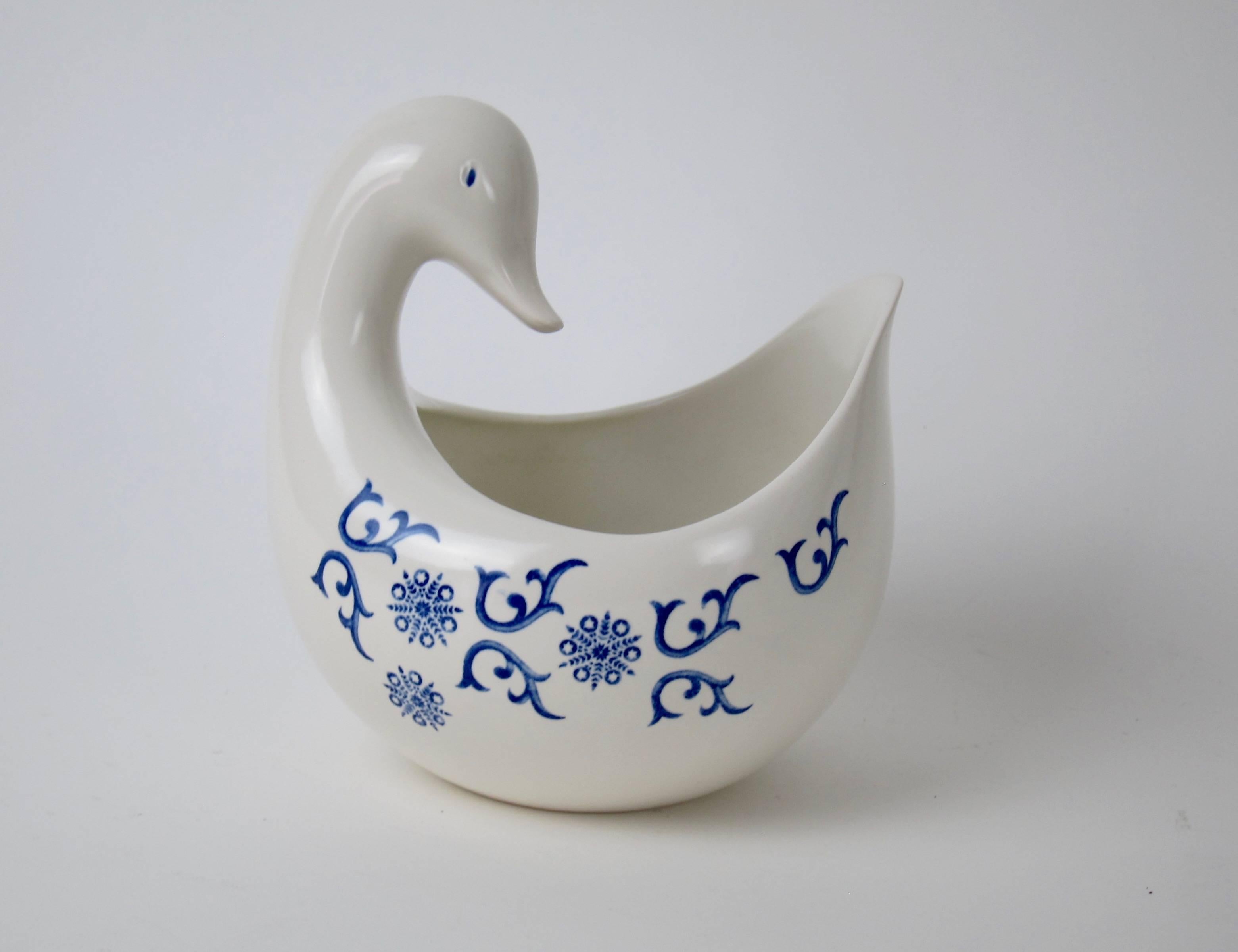 A whimsical, Mid-Century open vegetable or serving bowl designed by Eva Zeisel for Schmid International in the Stratford pattern featuring blue, abstract scrolls against a white ground. The open, bird shaped bowl either a duck or goose was