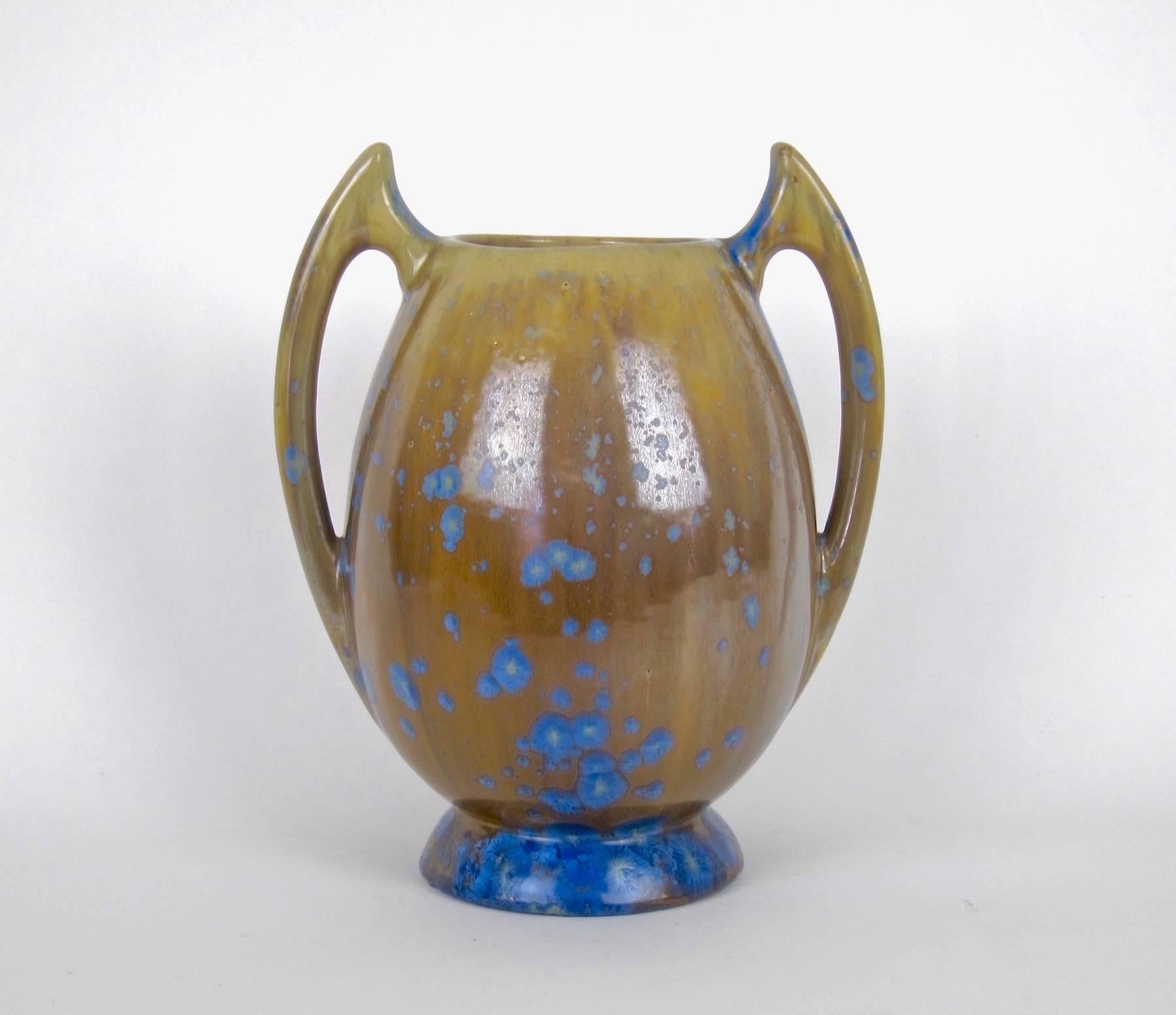 A handsome Art Nouveau stoneware vase from Pierrefonds Pottery of France. This sculptural and heavy antique vessel was crafted by hand at the turn of the 20th century, circa 1905. The vessel has two "batwing" handles and an attractive
